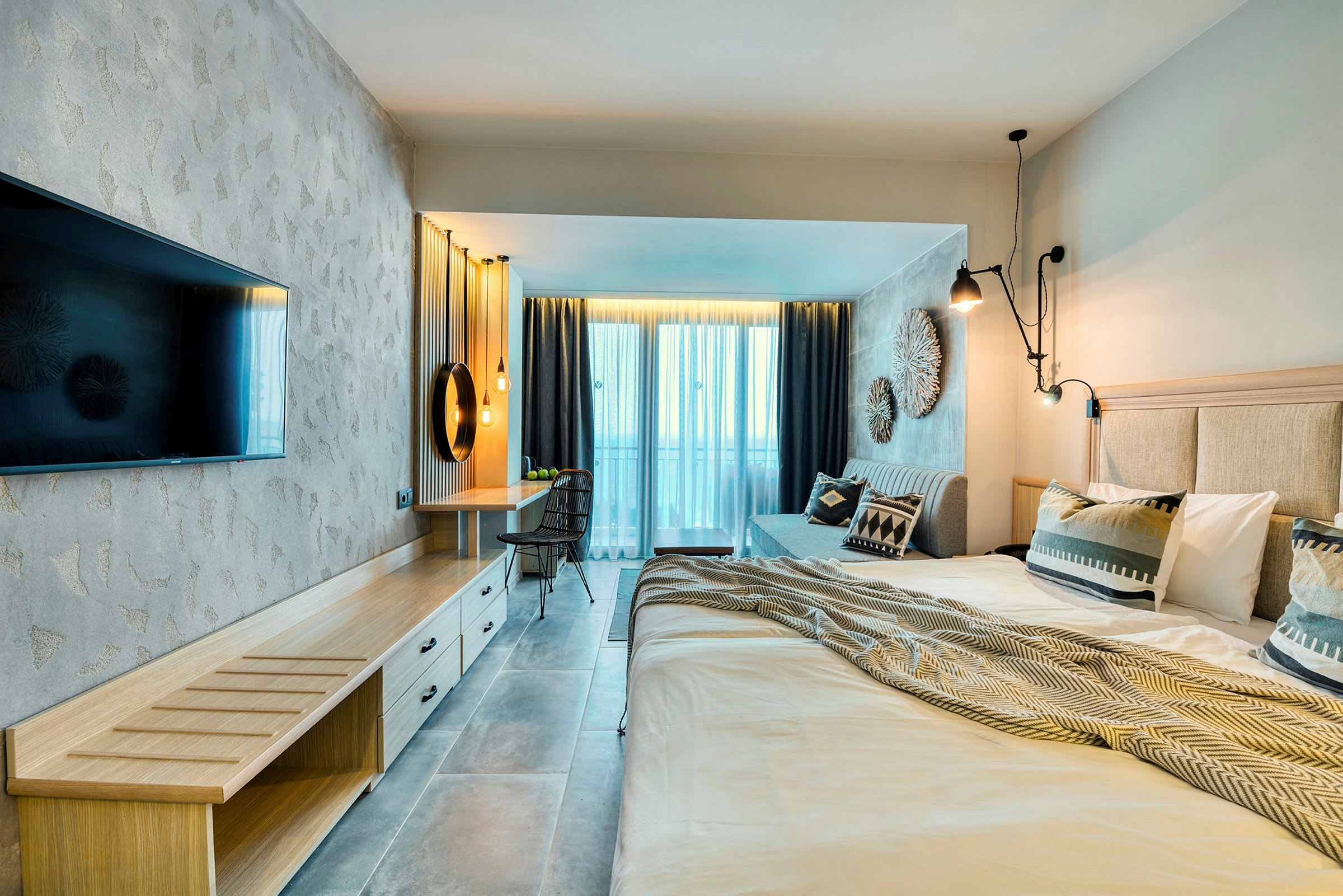 Moderni hotellihuone parivuoteella, televisiolla, työpöydällä ja parvekkeella. (Tekoälyn luoma teksti)