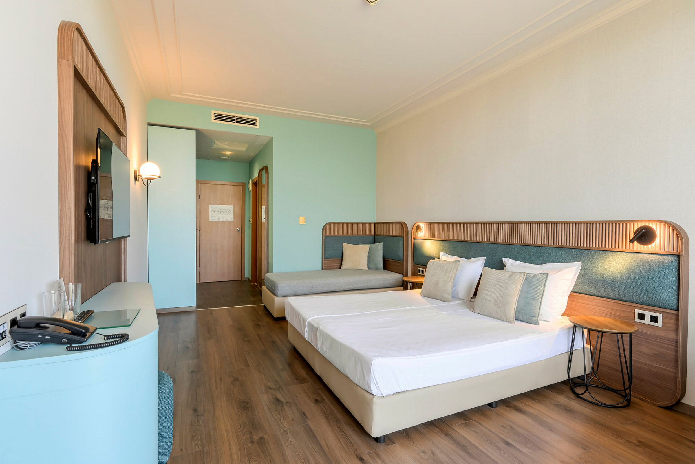 Hotellihuone, jossa on kaksi sänkyä ja sohva. (Tekoälyn luoma teksti)