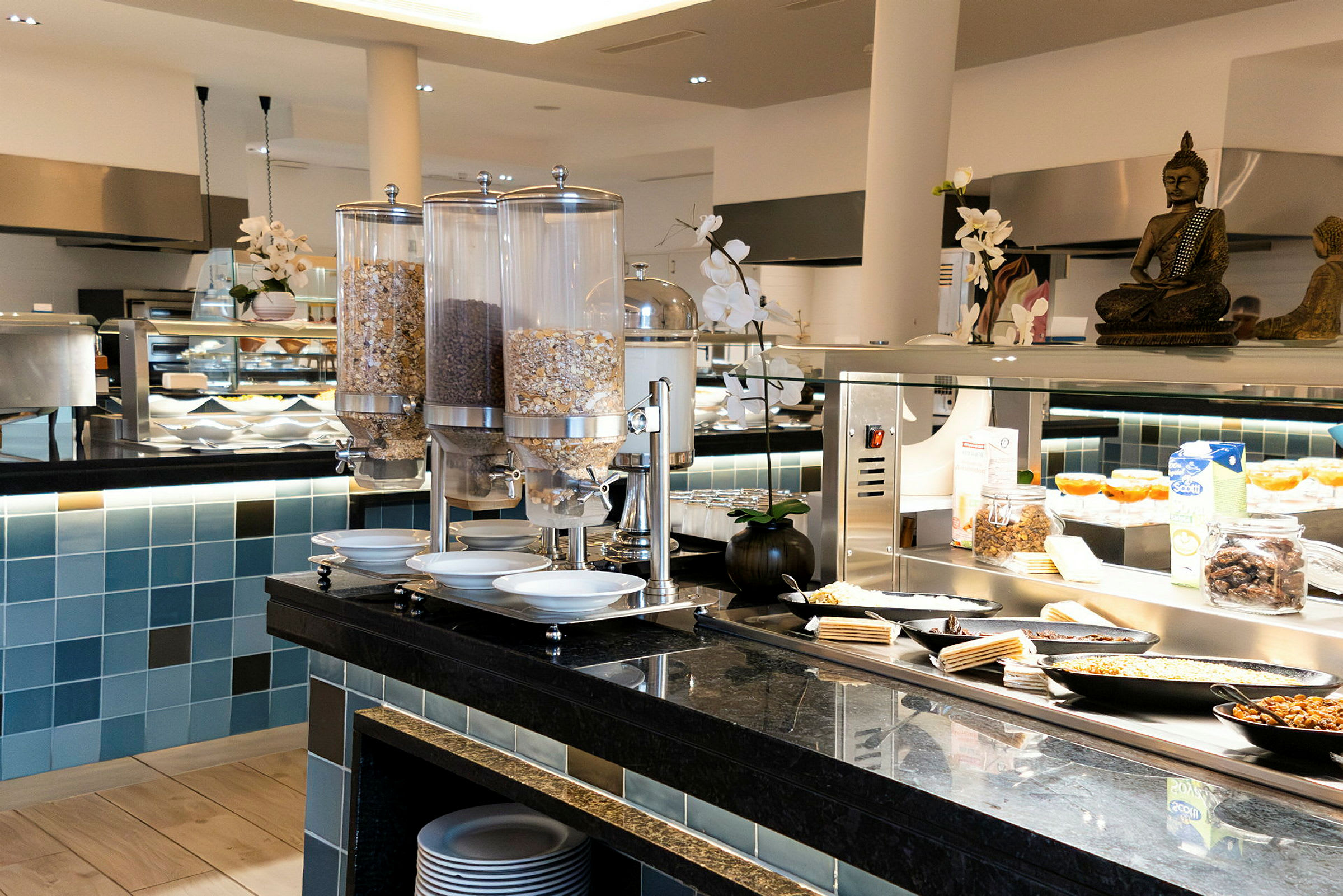Buffet, jossa erilaisia ruokavaihtoehtoja ja juomasäiliöitä nykyaikaisessa ympäristössä. (Tekoälyn luoma teksti)