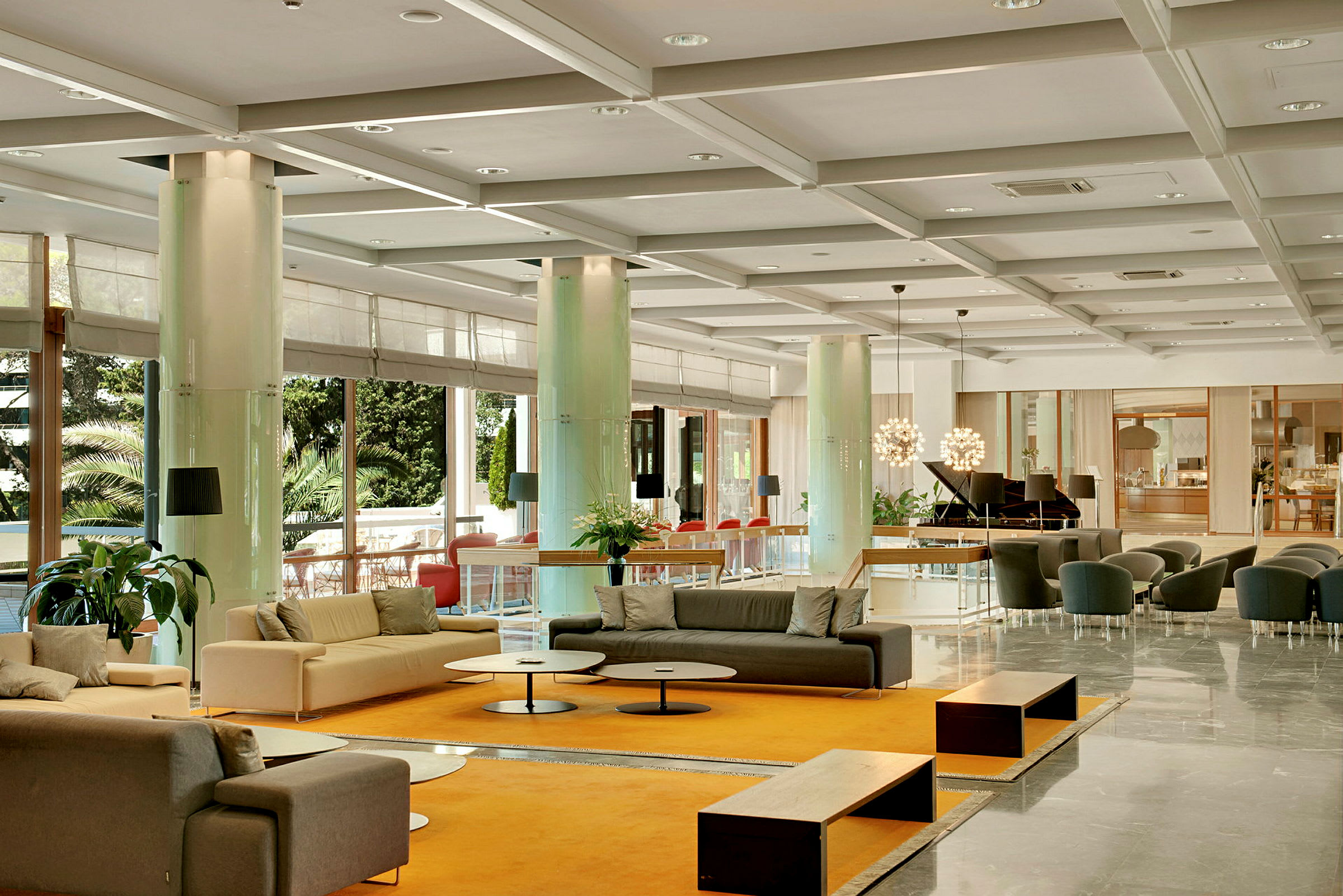 Valoisa ja avara hotellin aula, jossa on sohvia, pöytiä ja koristekasveja. (Tekoälyn luoma teksti)