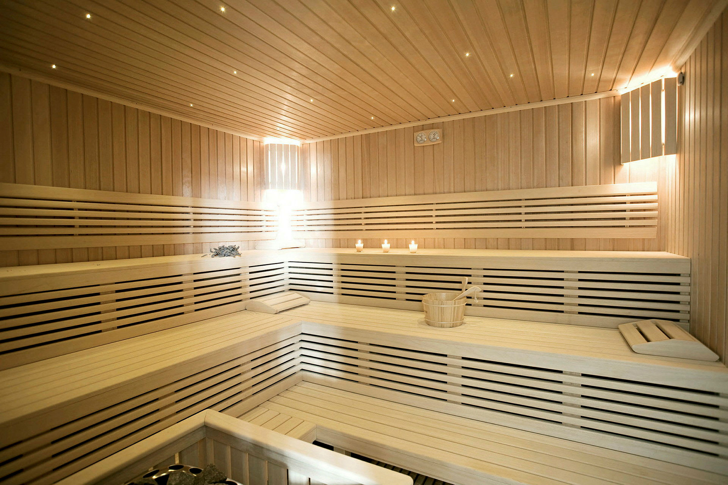 Sauna, jossa puiset penkit ja kynttilöitä. (Tekoälyn luoma teksti)