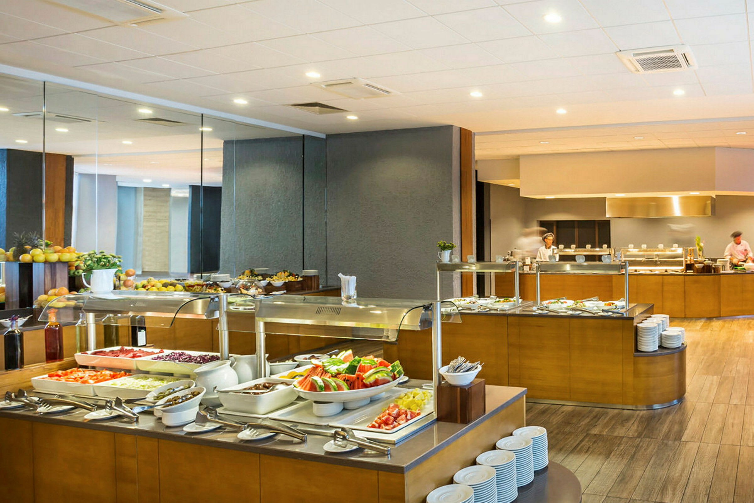 Buffet-alue, jossa on laaja valikoima ruokaa eri asemilla. (Tekoälyn luoma teksti)