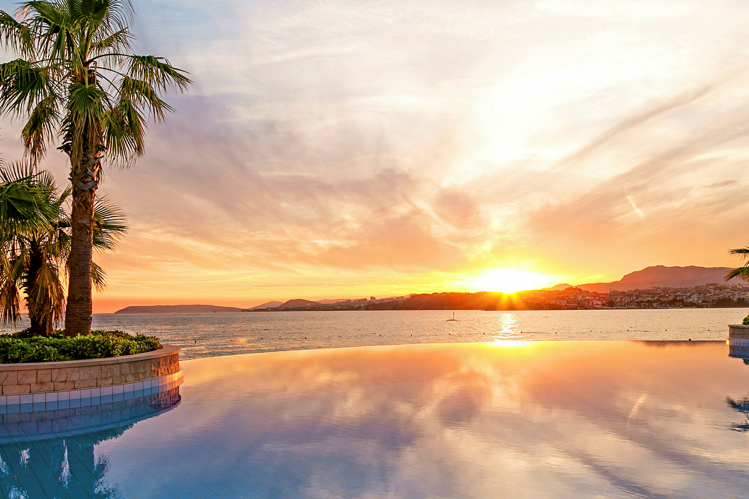 Uima-allas, josta on näkymä merelle auringonlaskun aikaan. (Tekoälyn luoma teksti)