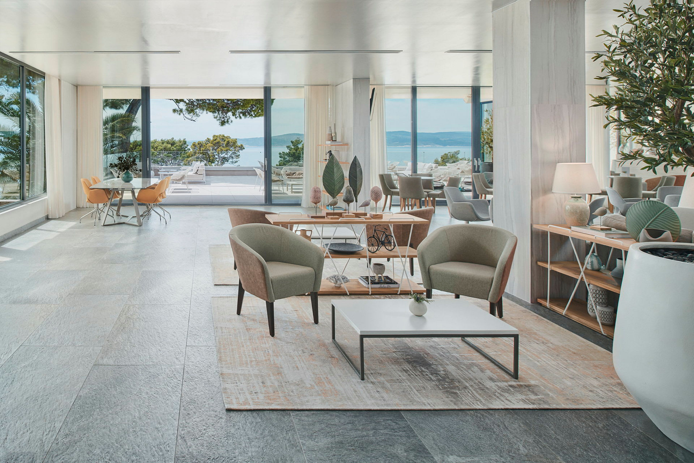Tyylikäs hotellihuone, jossa oleskelutila, suuret ikkunat ja merinäköala. (Tekoälyn luoma teksti)