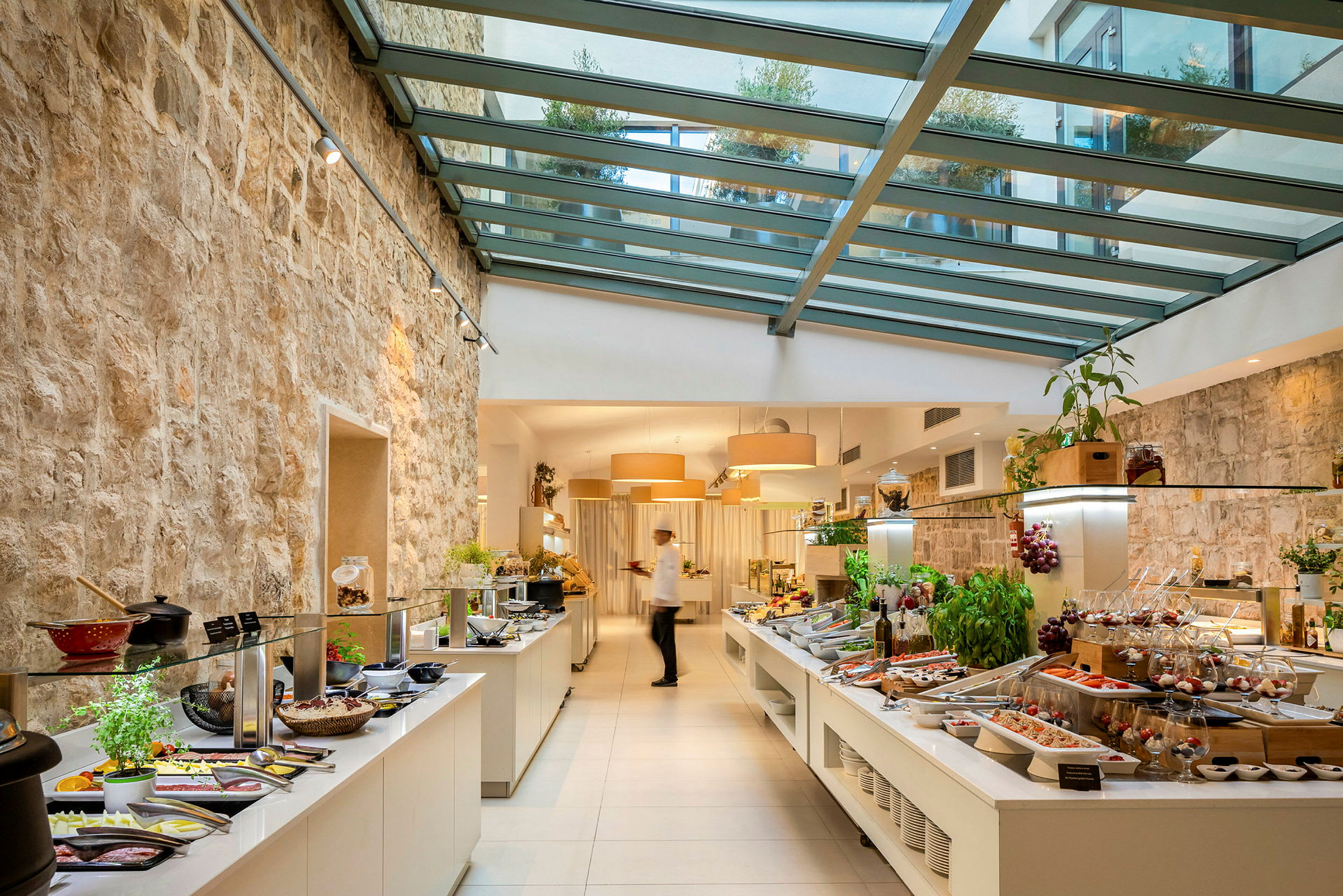 Buffet-alue, jossa lasikatto ja rustiikkinen kiviseinä. (Tekoälyn luoma teksti)