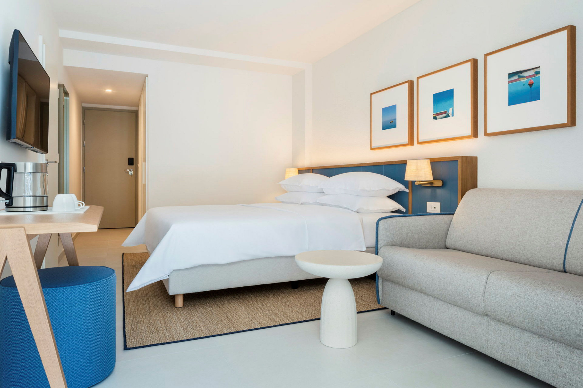 Hotellihuone, jossa sänky, sohva ja pöytä. (Tekoälyn luoma teksti)