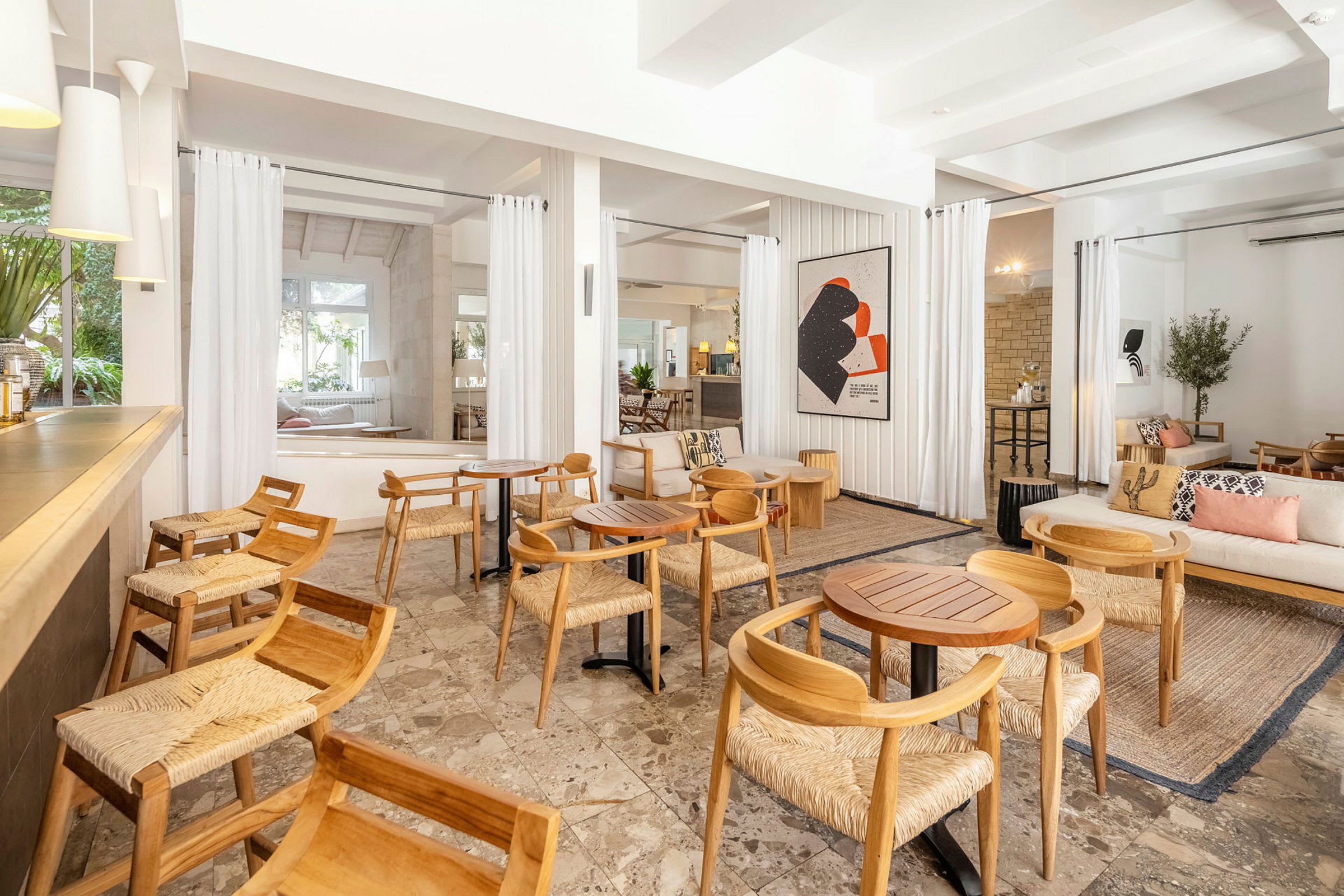Lounge, jossa puiset tuolit ja pöydät, valoisa ja moderni sisustus. (Tekoälyn luoma teksti)