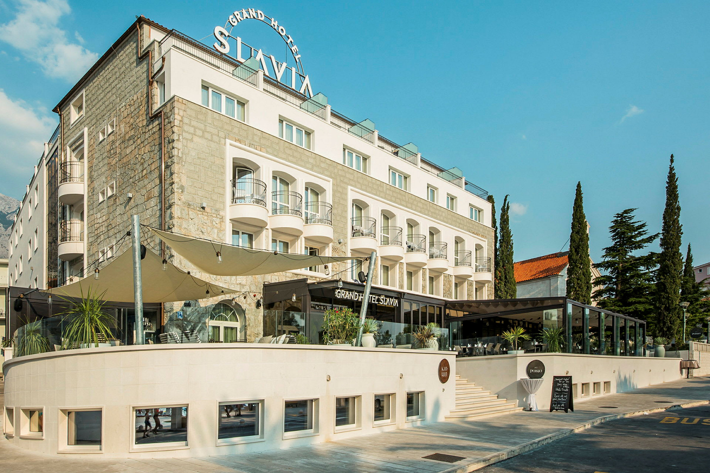 Rakennus, jossa on kyltti 'Grand Hotel Slavia'. (Tekoälyn luoma teksti)