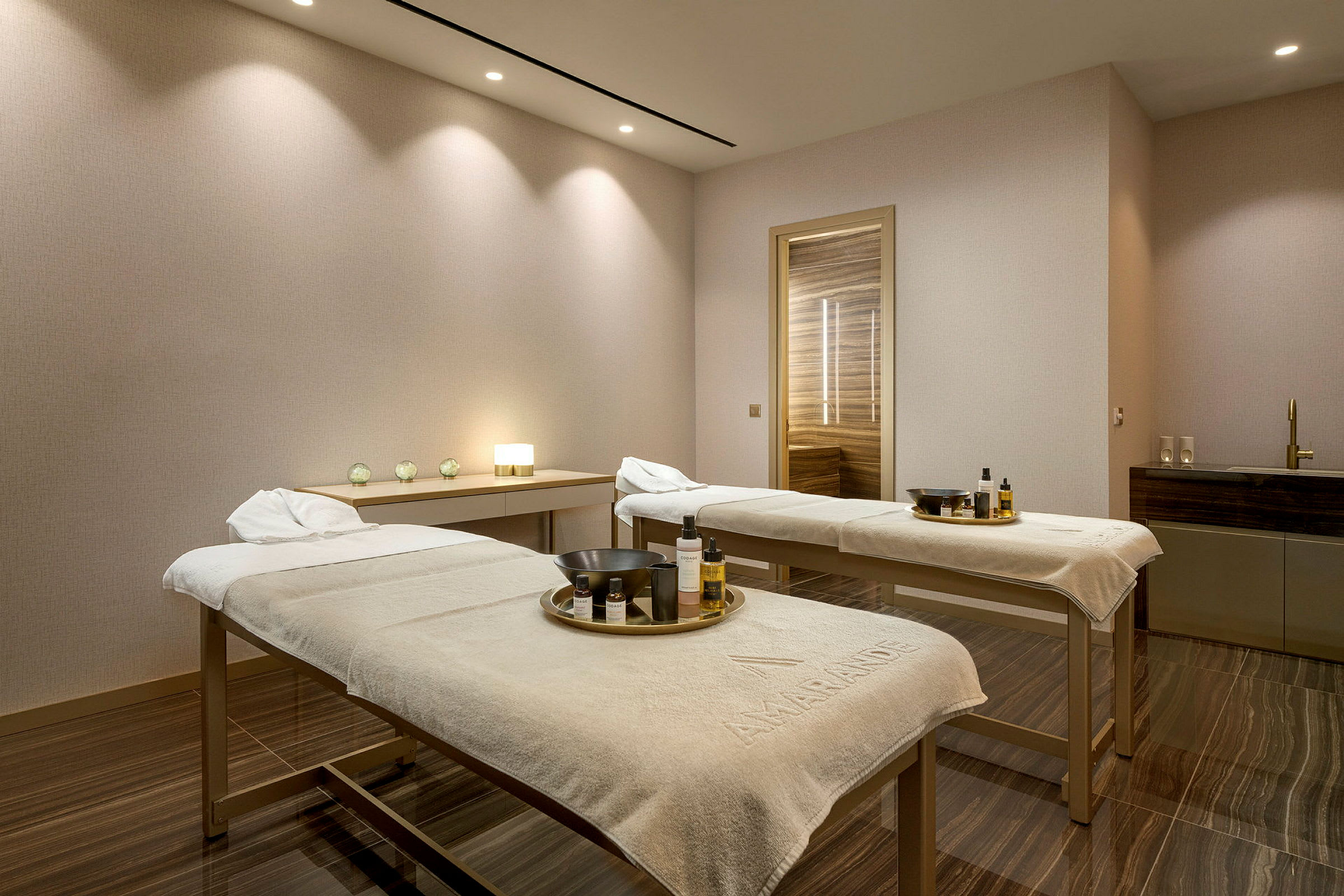 Kaksi hierontapöytää spa-huoneessa himmeällä valaistuksella. (Tekoälyn luoma teksti)