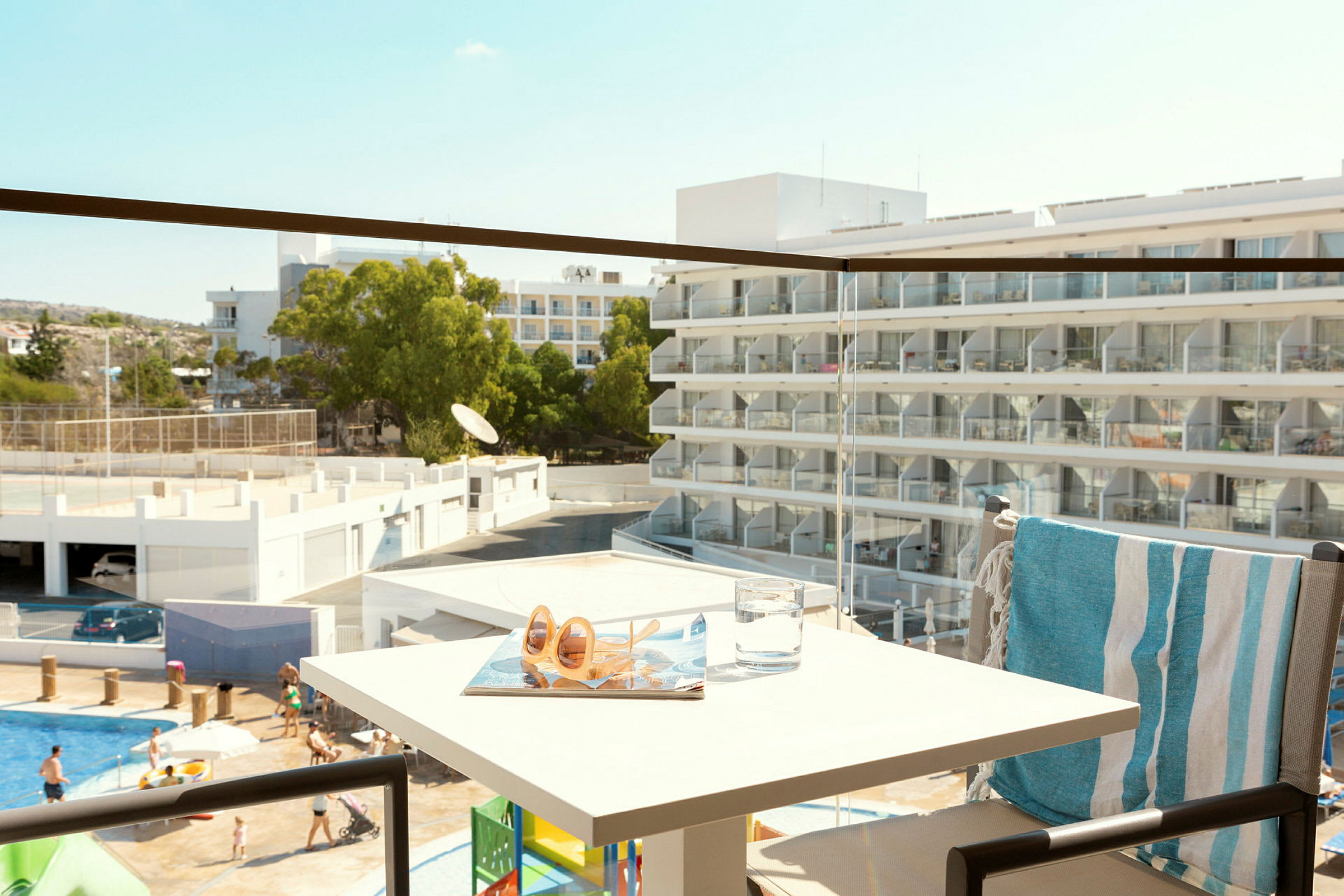 Näkymä parvekkeelta hotellirakennukseen, jossa on parvekkeita ja ihmisiä altaalla. (Tekoälyn luoma teksti)