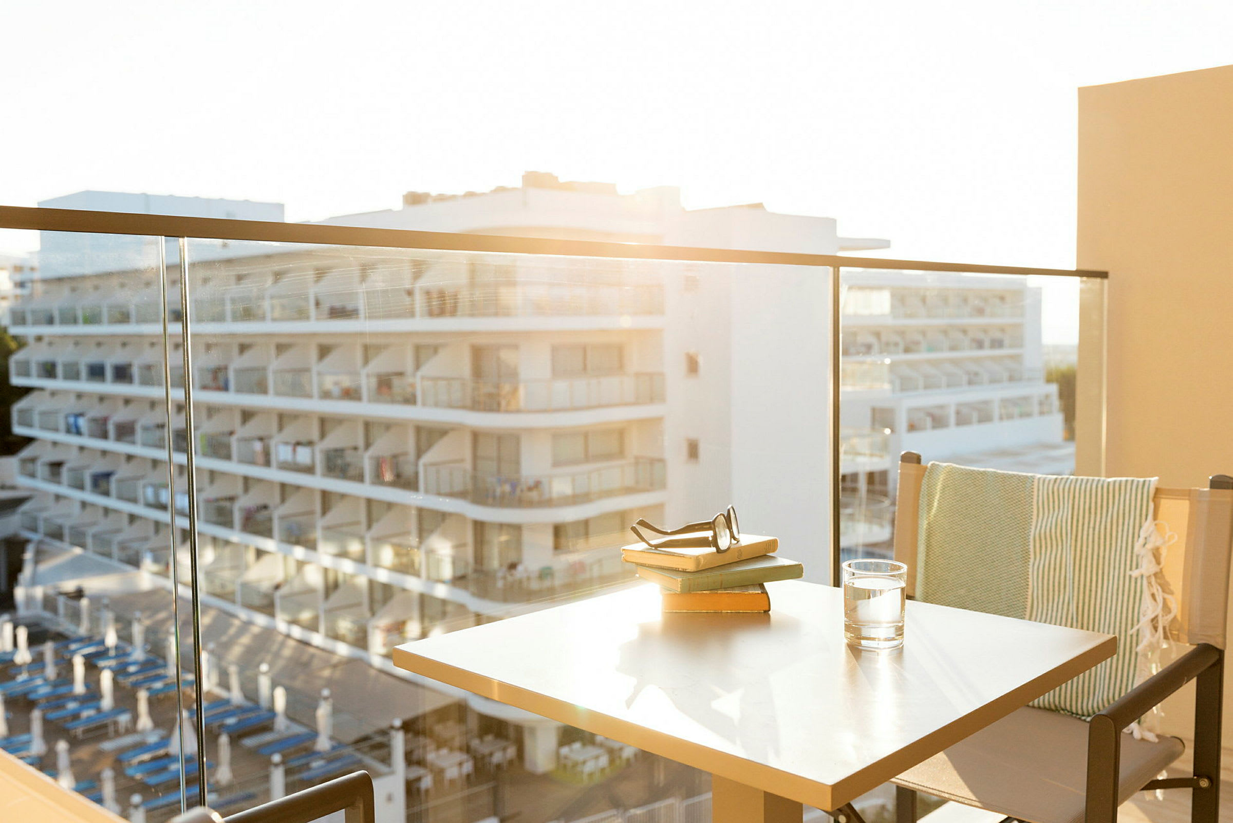Näkymä parvekkeelta lasikaiteen läpi hotellille, jossa on parvekkeita. (Tekoälyn luoma teksti)