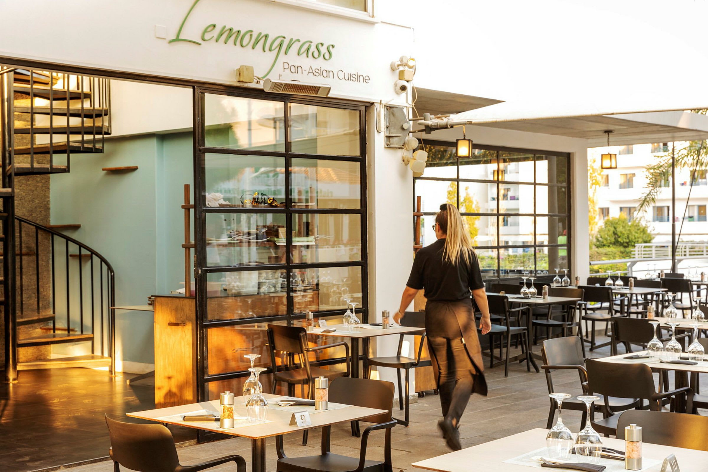 Lemongrass-niminen ravintola ja tarjoilija kulkemassa pöytien välissä. (Tekoälyn luoma teksti)