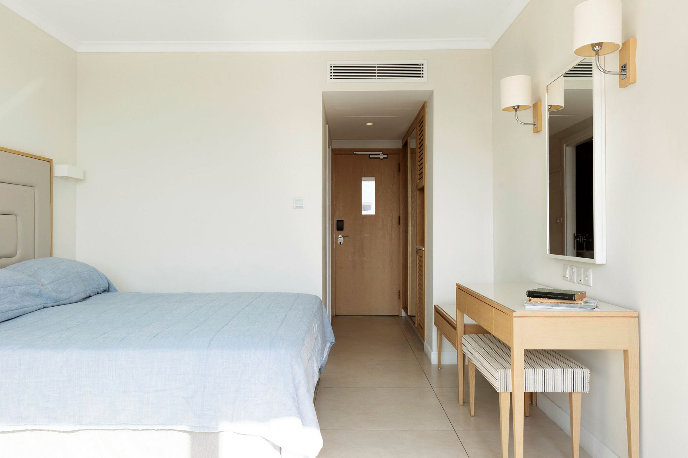Hotellihuone, jossa sänky, peili ja työpöytä. (Tekoälyn luoma teksti)