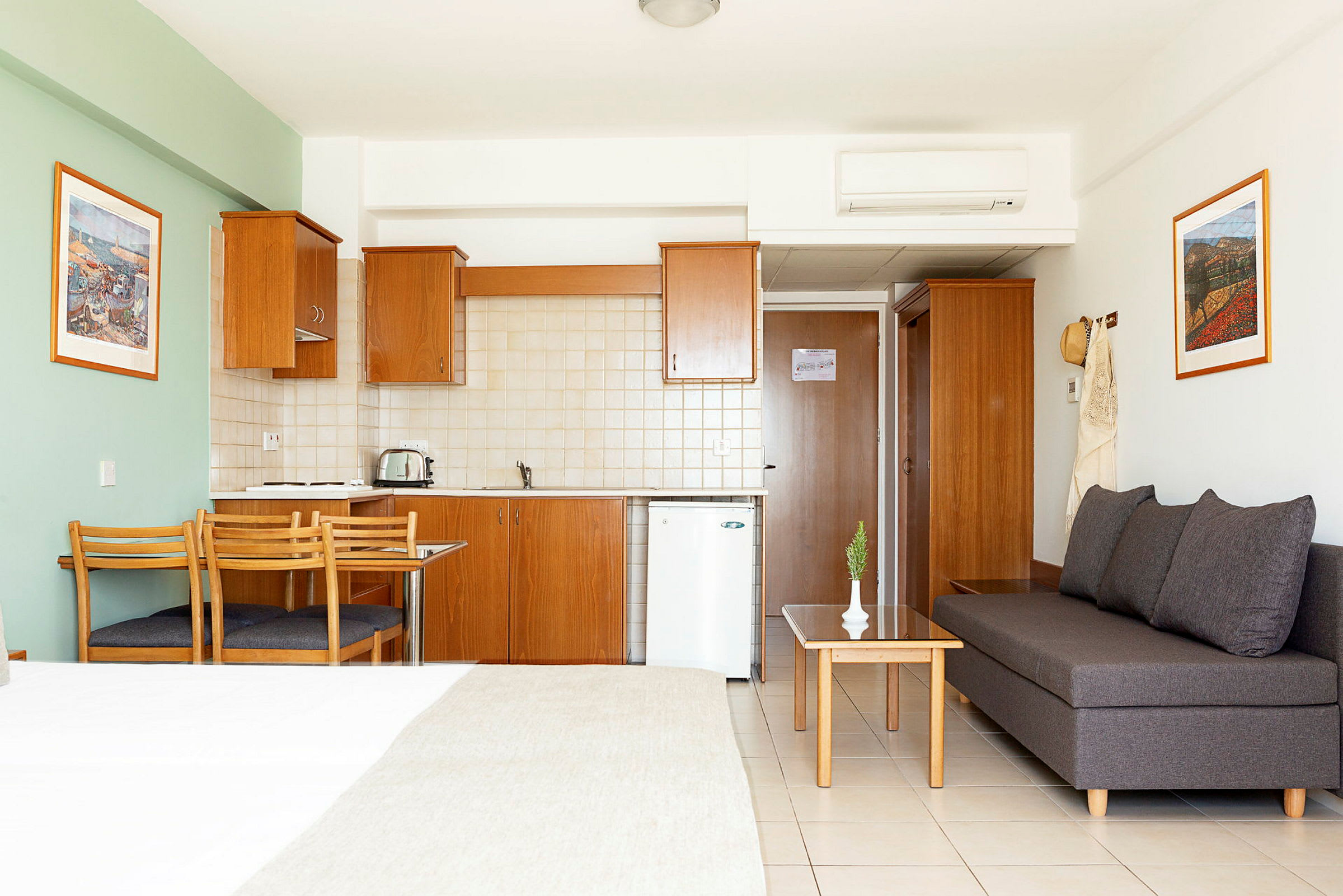 Hotellistudio, jossa keittiö, ruokapöytä ja istuinryhmä. (Tekoälyn luoma teksti)