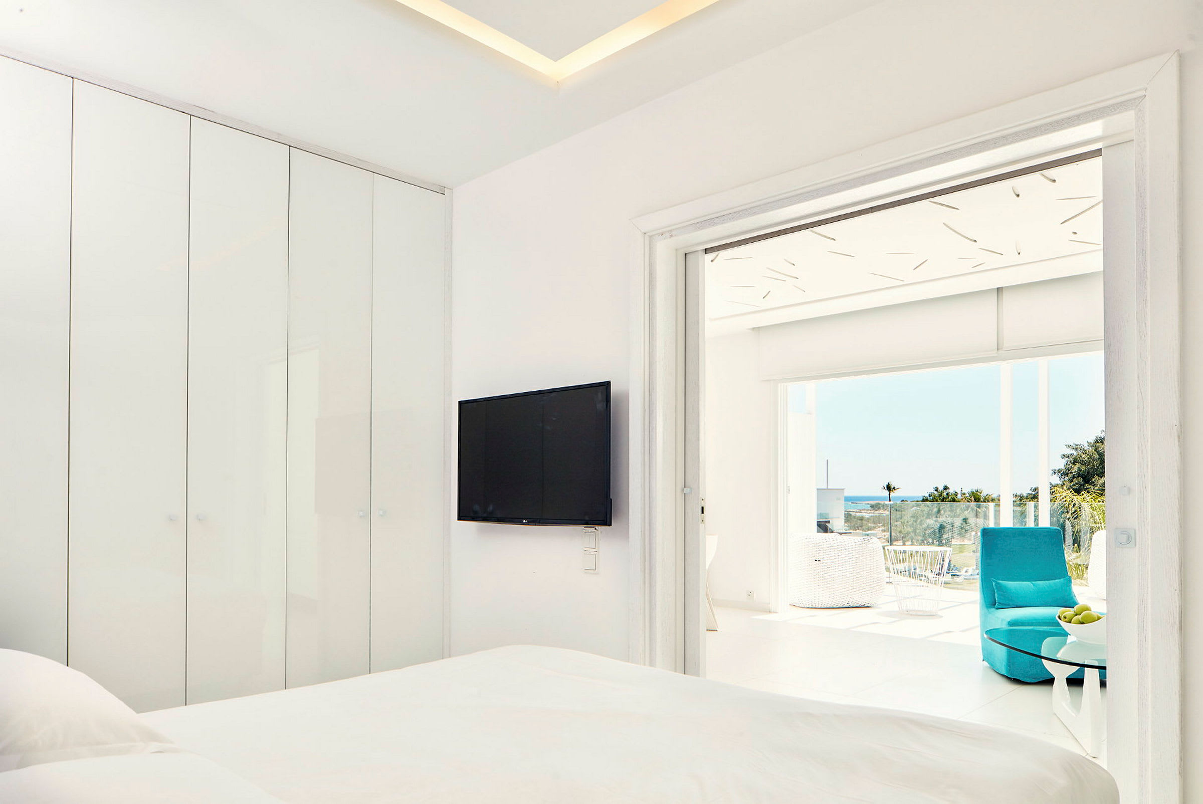 Moderni hotellihuone, jossa taulutelevisio ja parveke näköalalla. (Tekoälyn luoma teksti)