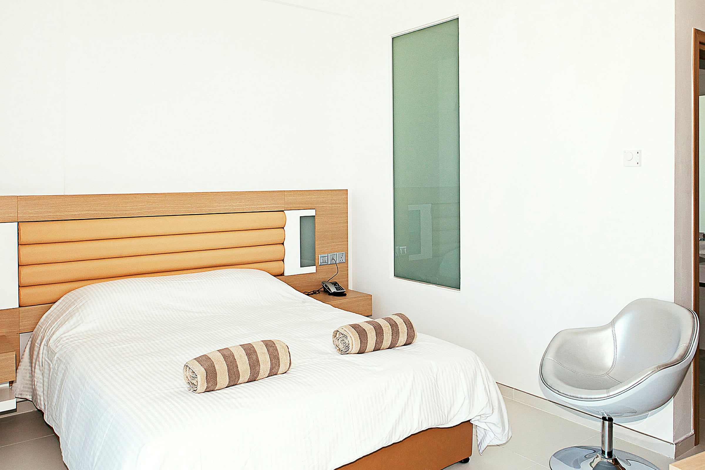 Hotellihuone, jossa on sänky ja minimalistinen sisustus. (Tekoälyn luoma teksti)