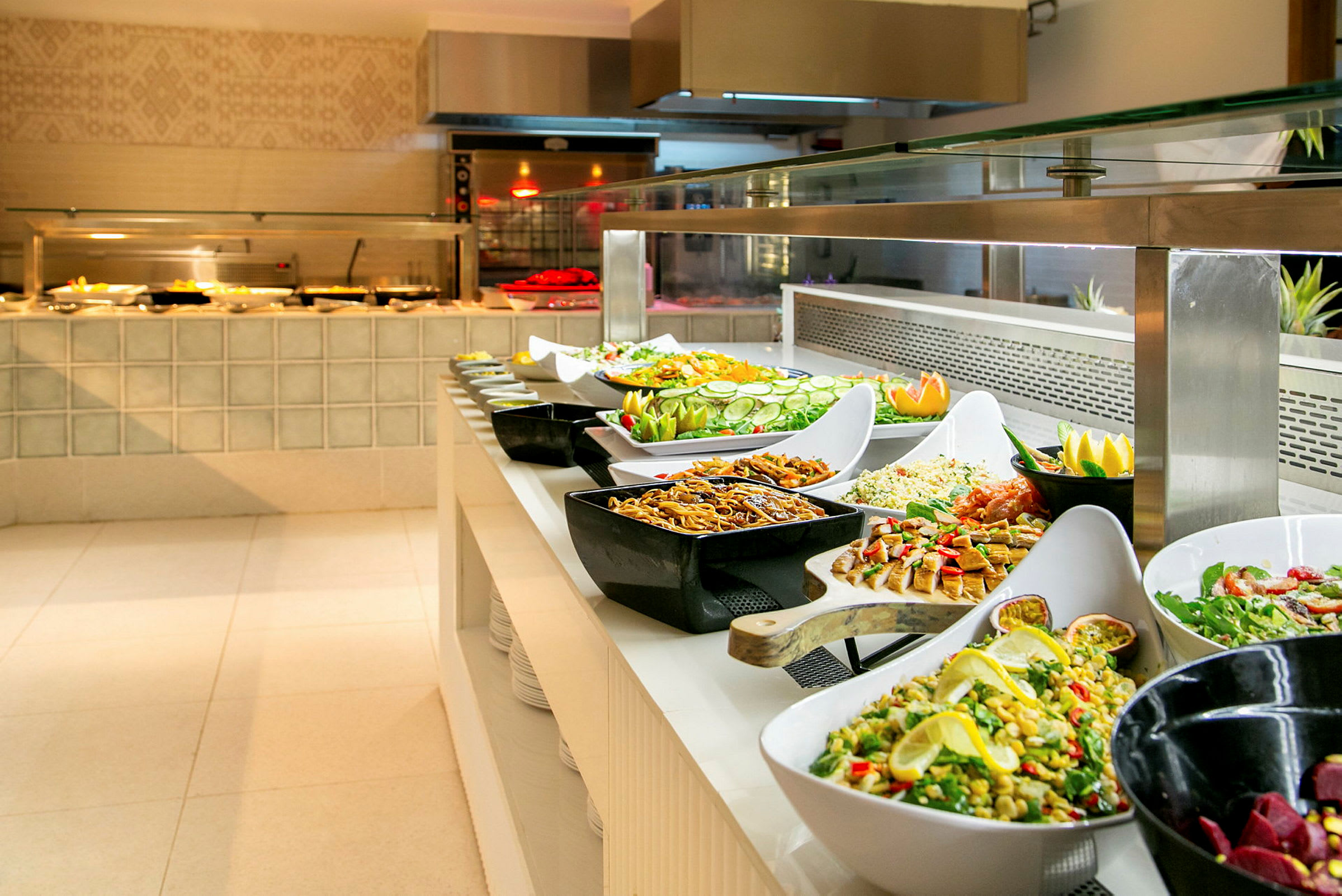 Buffet, jossa on erilaisia ruokalajeja ja salaatteja. (Tekoälyn luoma teksti)