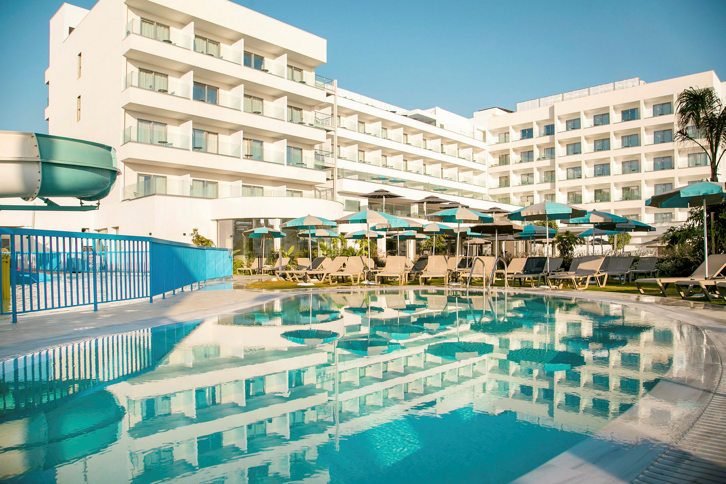 Hotellirakennus parvekkeineen ja uima-allas etualalla. (Tekoälyn luoma teksti)