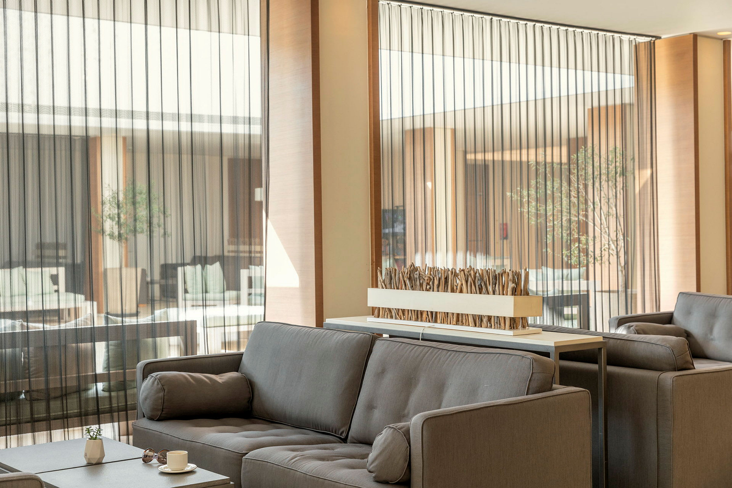 Moderni lounge, jossa harmaat sohvat ja koristeellinen pöytäasettelu. (Tekoälyn luoma teksti)