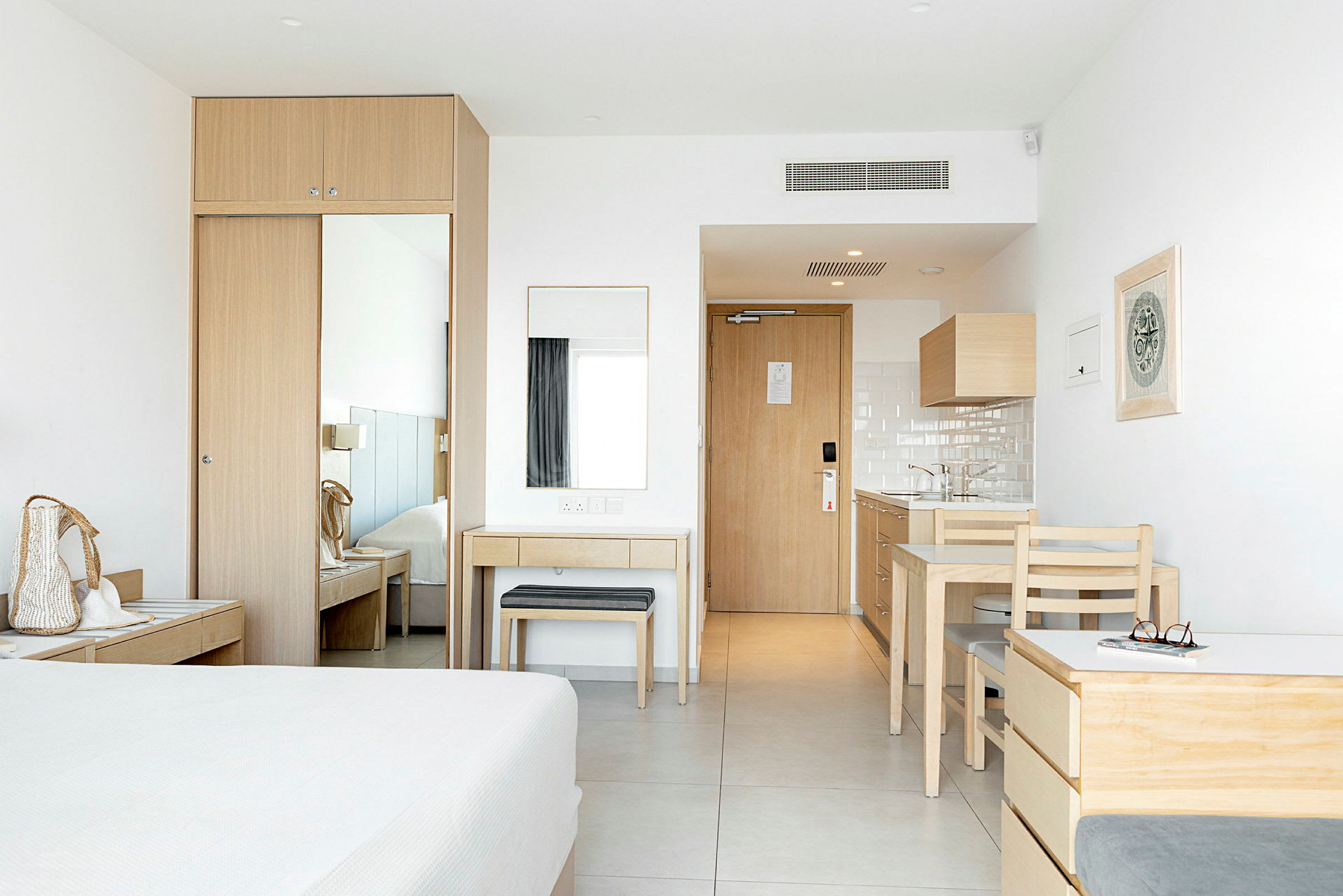 Hotellihuone, jossa on vaalea sisustus ja puiset huonekalut. (Tekoälyn luoma teksti)