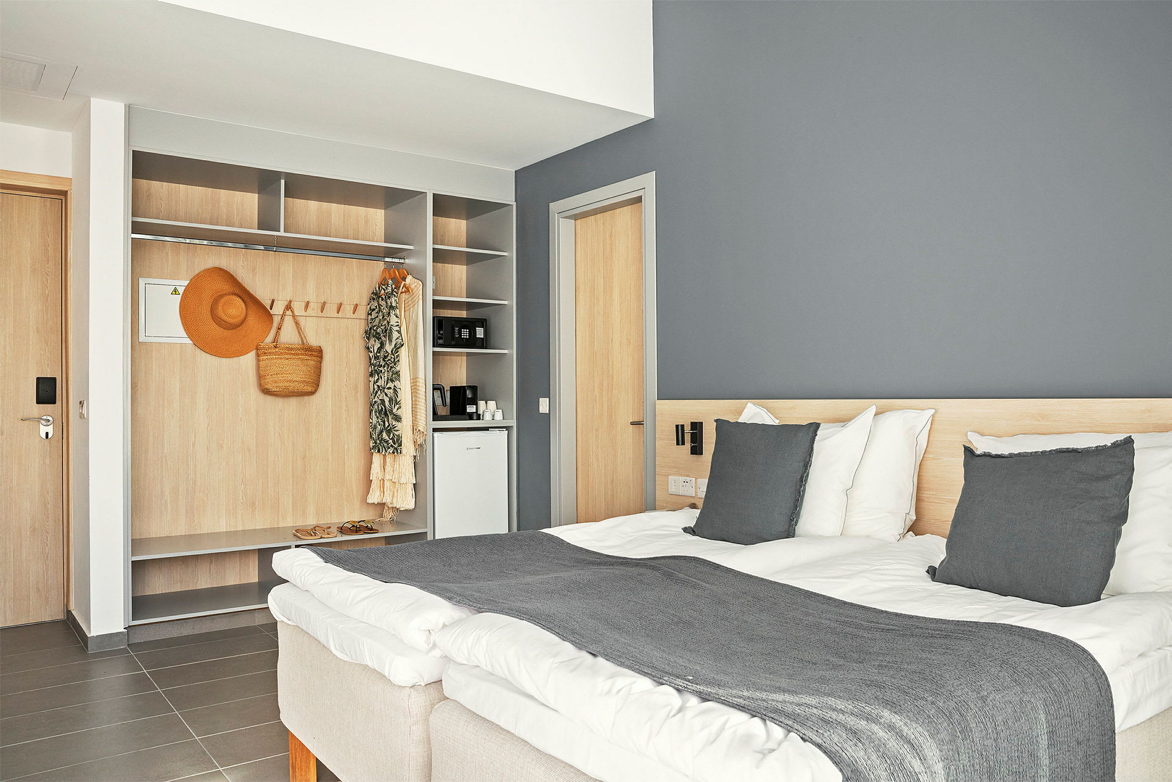 Hotellihuone, jossa on parivuode, sisäänrakennettu vaatekaappi ja minibaari. (Tekoälyn luoma teksti)