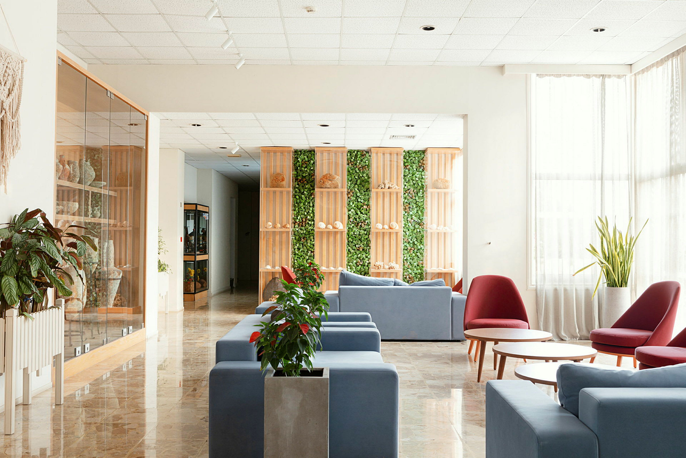 Hotellin aula, jossa on modernit huonekalut ja kasvisisustus. (Tekoälyn luoma teksti)
