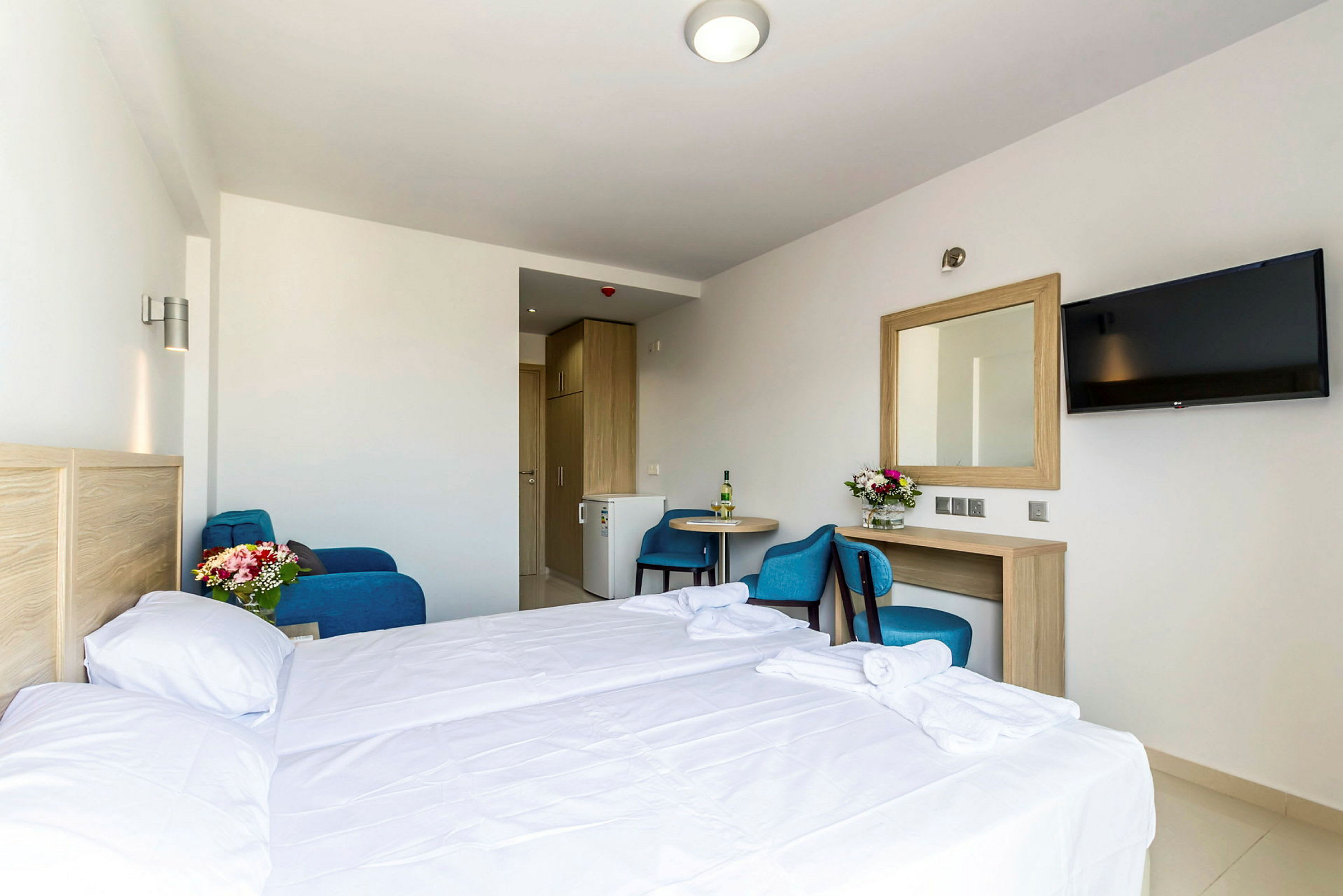 Hotellihuone, jossa sänky, pöytä, tuoli, peili ja televisio. (Tekoälyn luoma teksti)