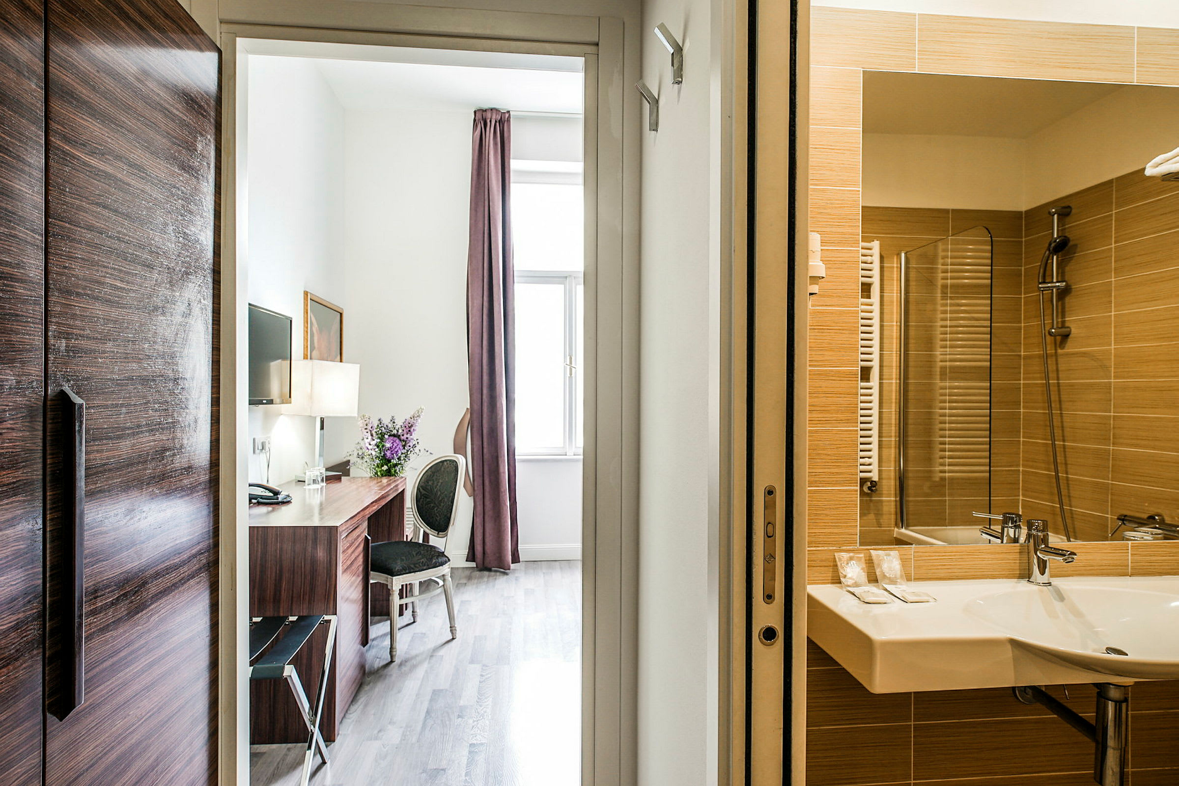 Hotellihuone, jossa näkyy työpöytä ja kylpyhuone. (Tekoälyn luoma teksti)