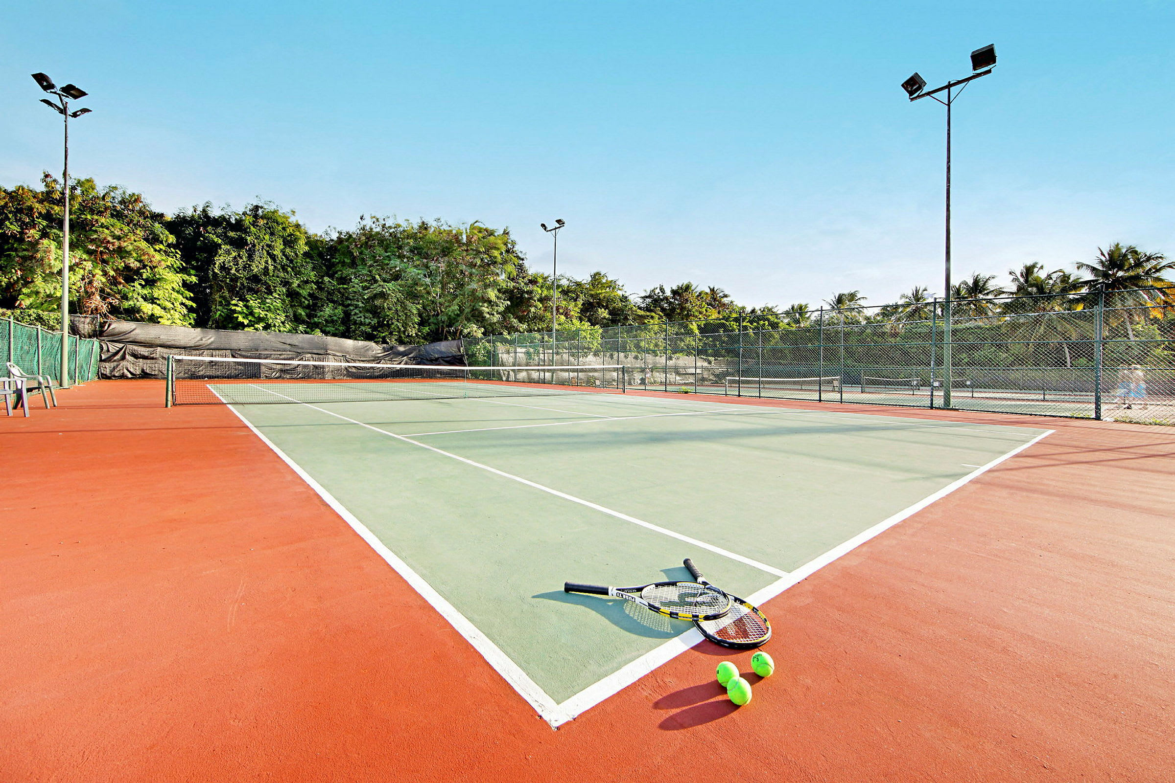 Tennispiha, jossa mailoja ja palloja maassa. (Tekoälyn luoma teksti)