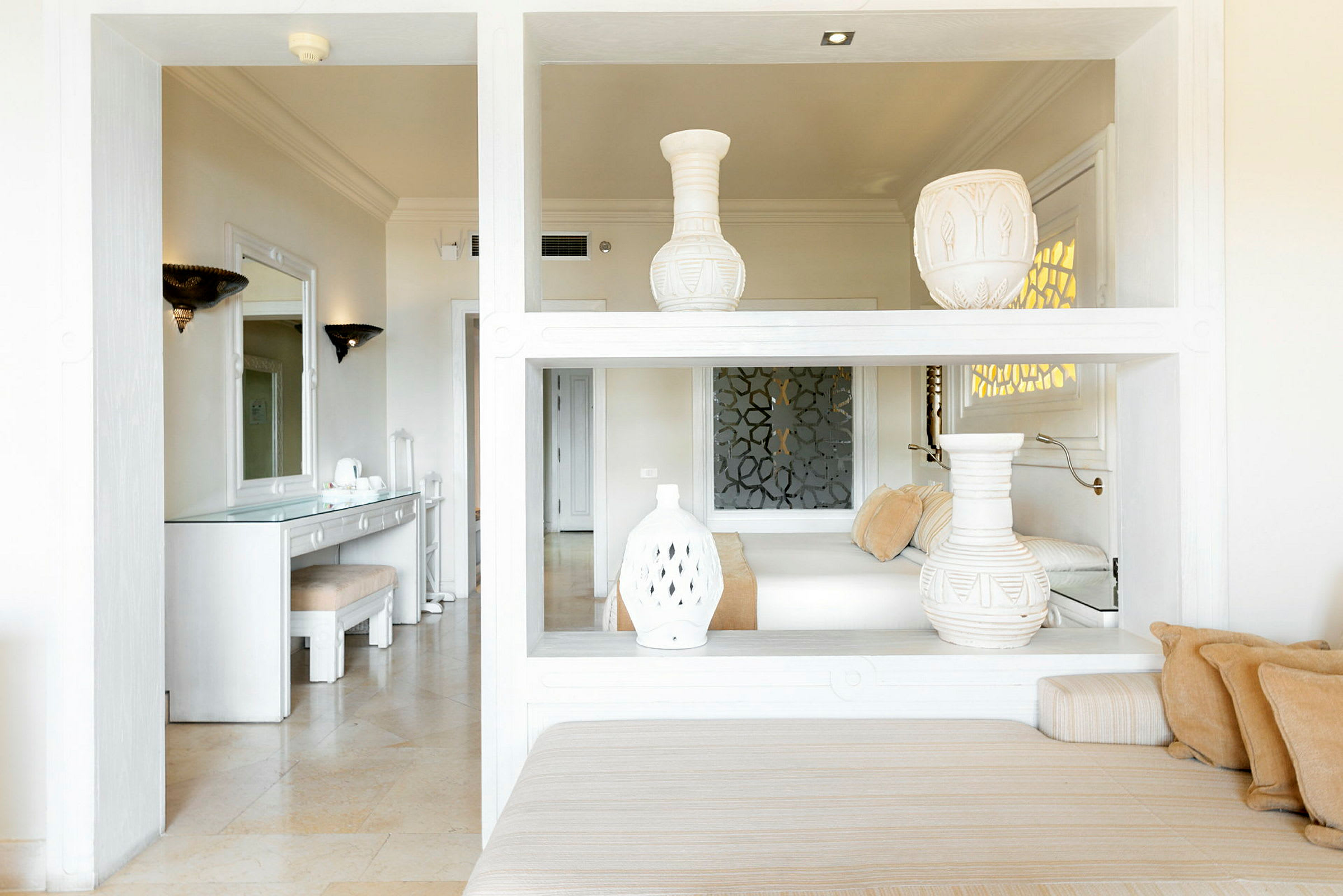 Vaalea hotellihuone, jossa koristeita ja nykyaikainen sisustus. (Tekoälyn luoma teksti)