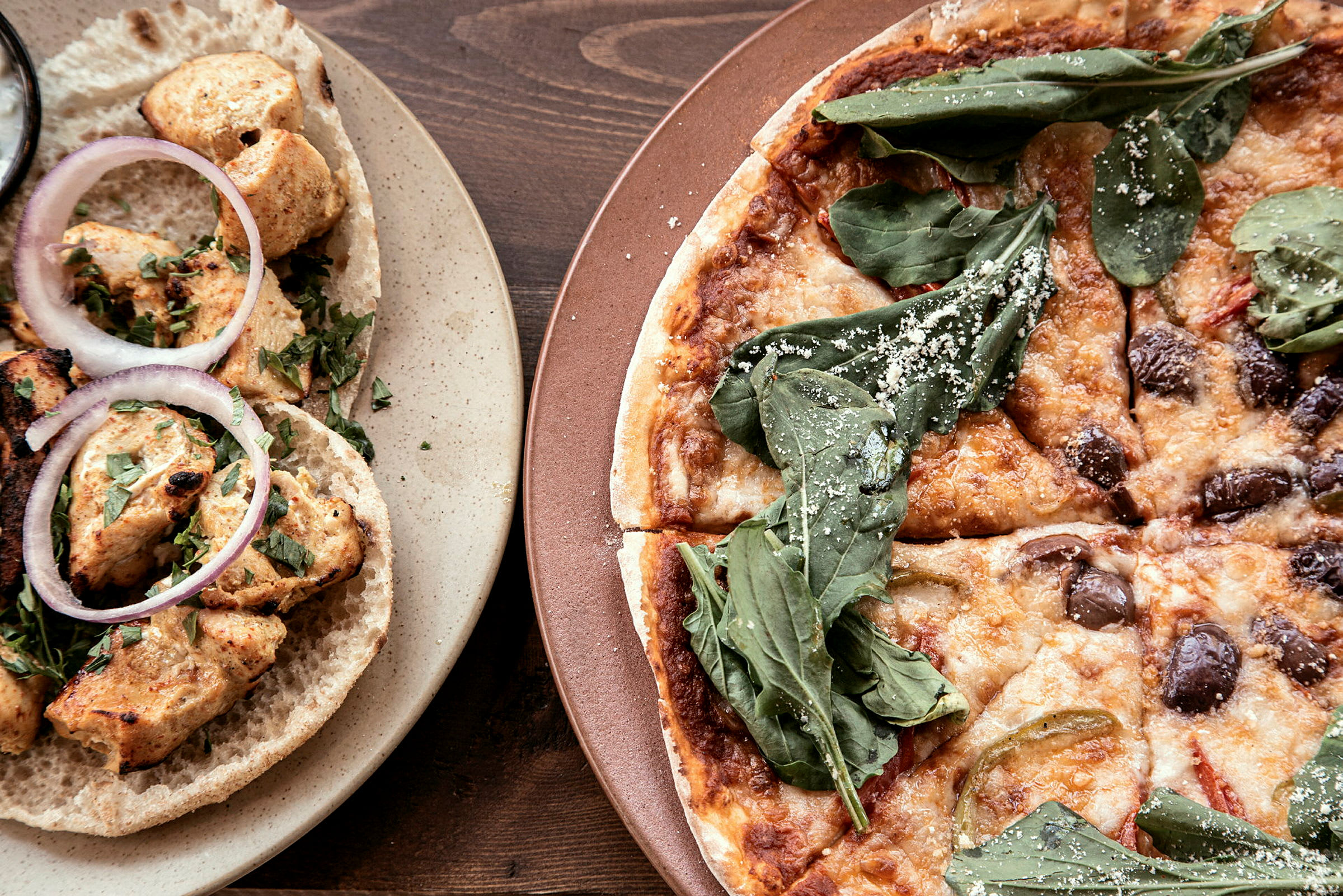 Ruokakuva, jossa näkyy kanawrappeja ja pizzaa. (Tekoälyn luoma teksti)
