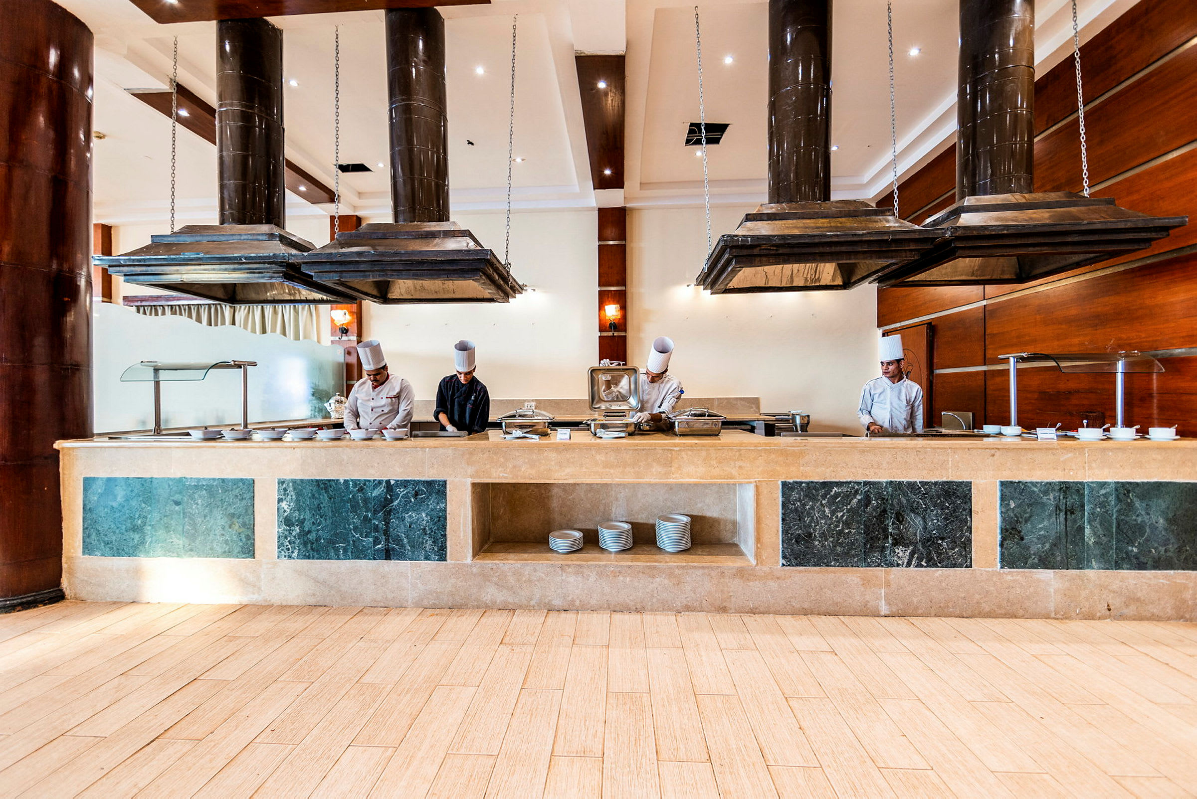 Hotellin ravintola, jossa on buffet-tiski ja keittiövälineitä suurten liesituulettimien alla. (Tekoälyn luoma teksti)