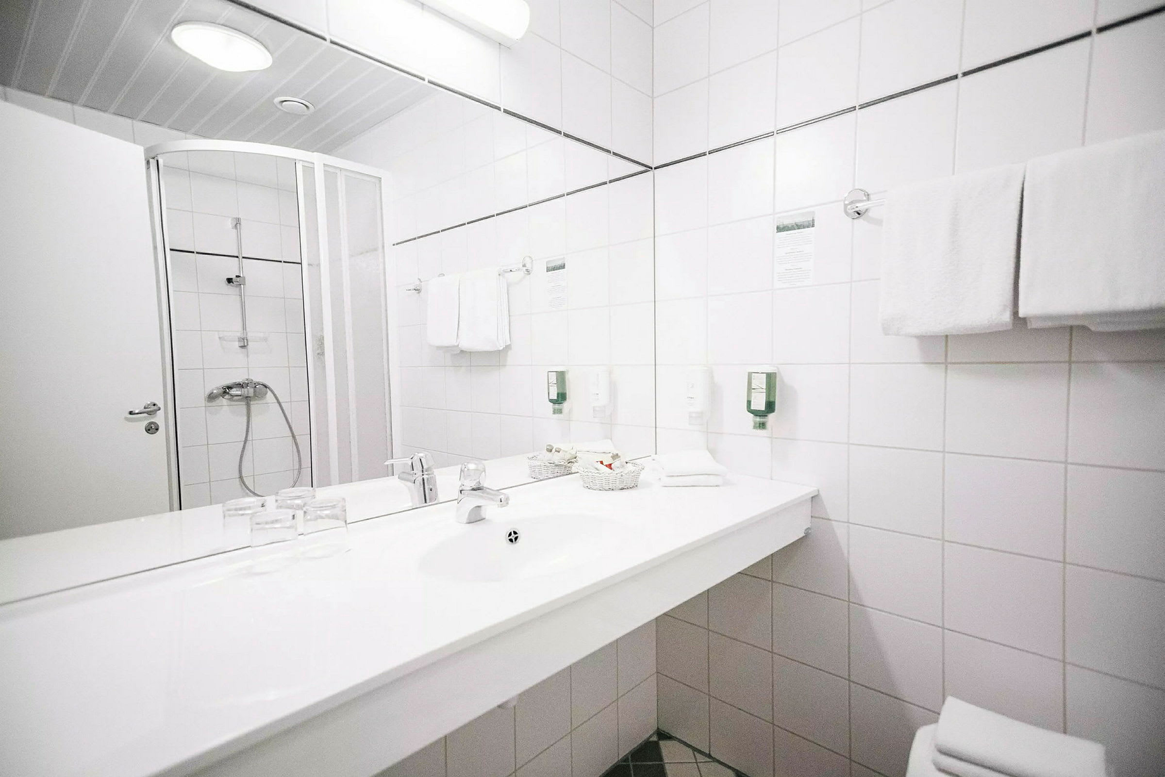 Kylpyhuone, jossa suihkukaappi, pesuallas ja peili. (Tekoälyn luoma teksti)
