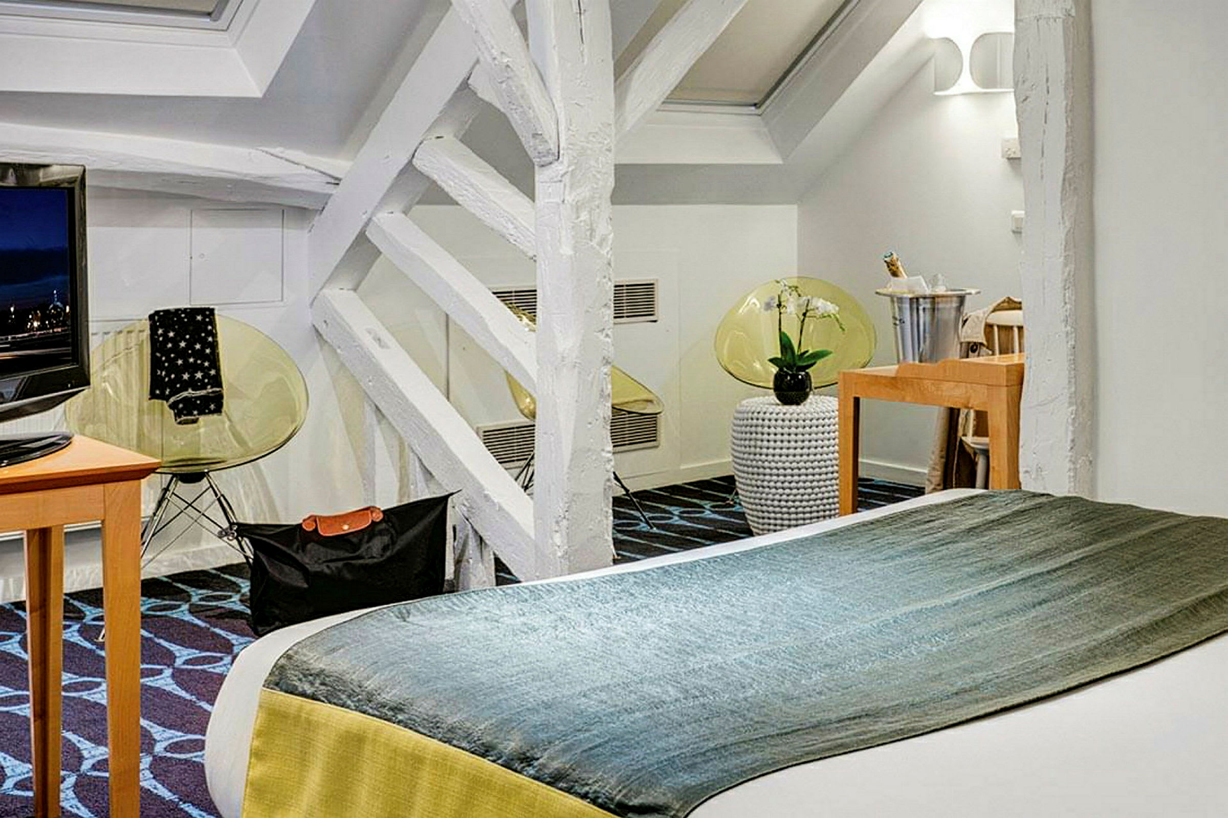 Moderni hotellihuone, jossa on parivuode, TV ja koristeellisia yksityiskohtia. (Tekoälyn luoma teksti)