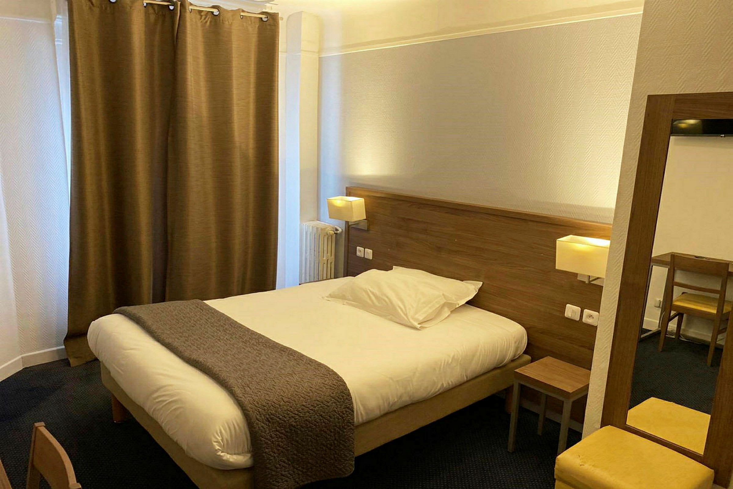 Hotellihuone, jossa on parivuode, yöpöytä ja kirjoituspöytä. (Tekoälyn luoma teksti)