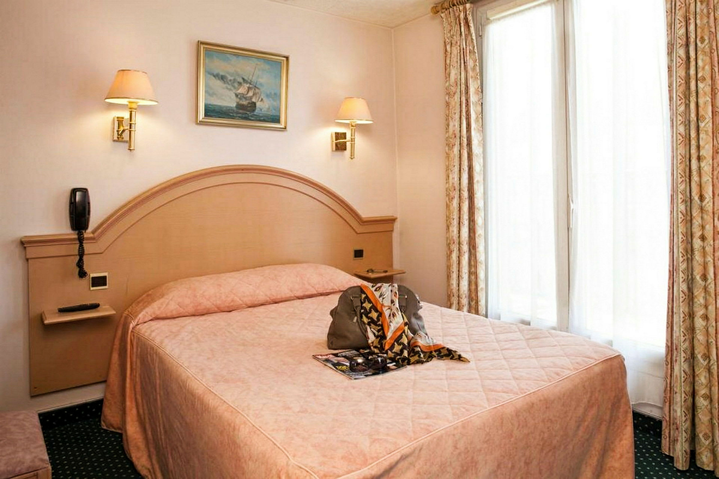 Hotellihuone, jossa on parivuode, beige sisustus ja verhot sekä seinällä oleva taulu. (Tekoälyn luoma teksti)