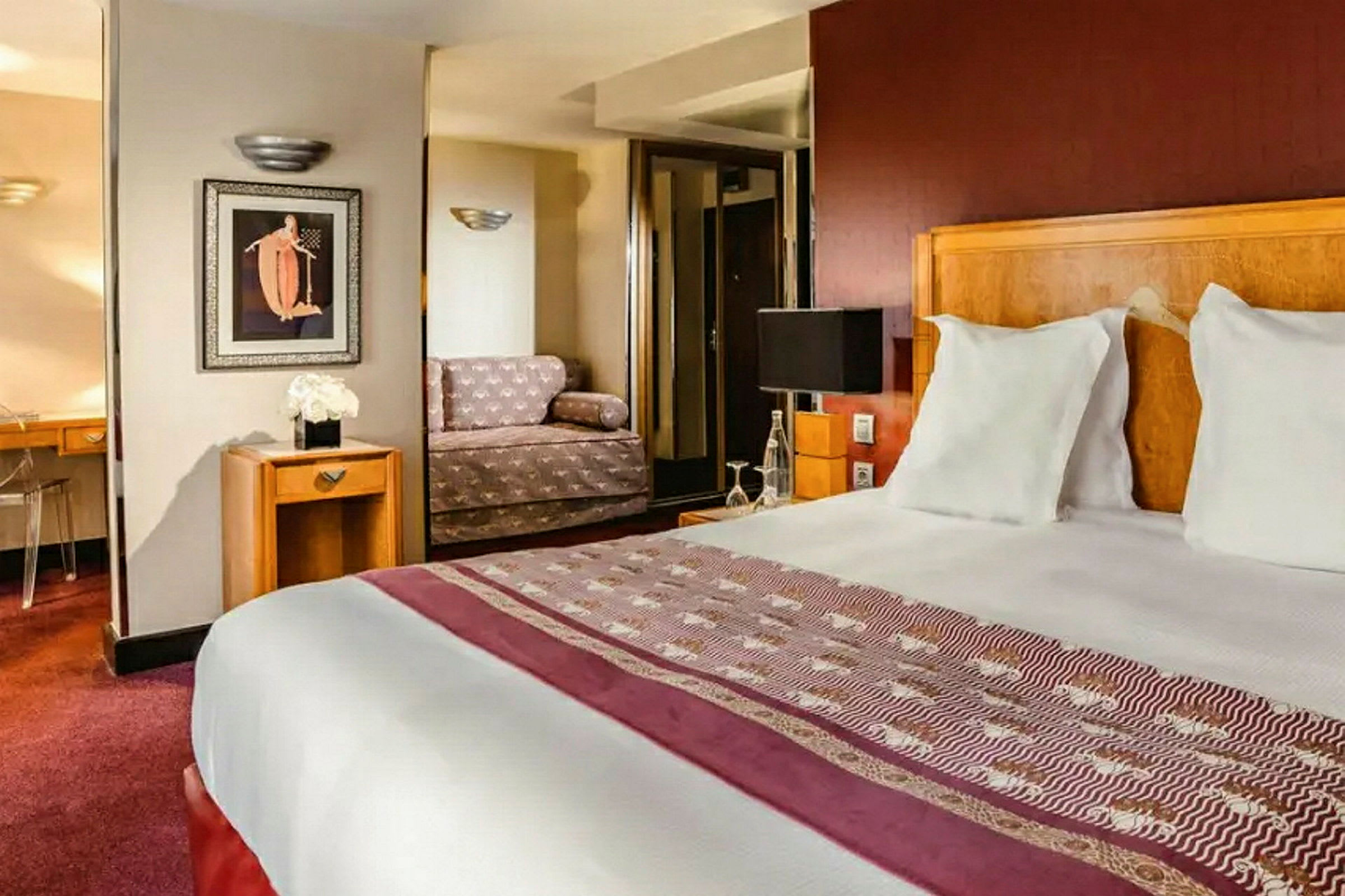 Hotellihuone, jossa on parivuode, sohva ja kirjoituspöytä. (Tekoälyn luoma teksti)