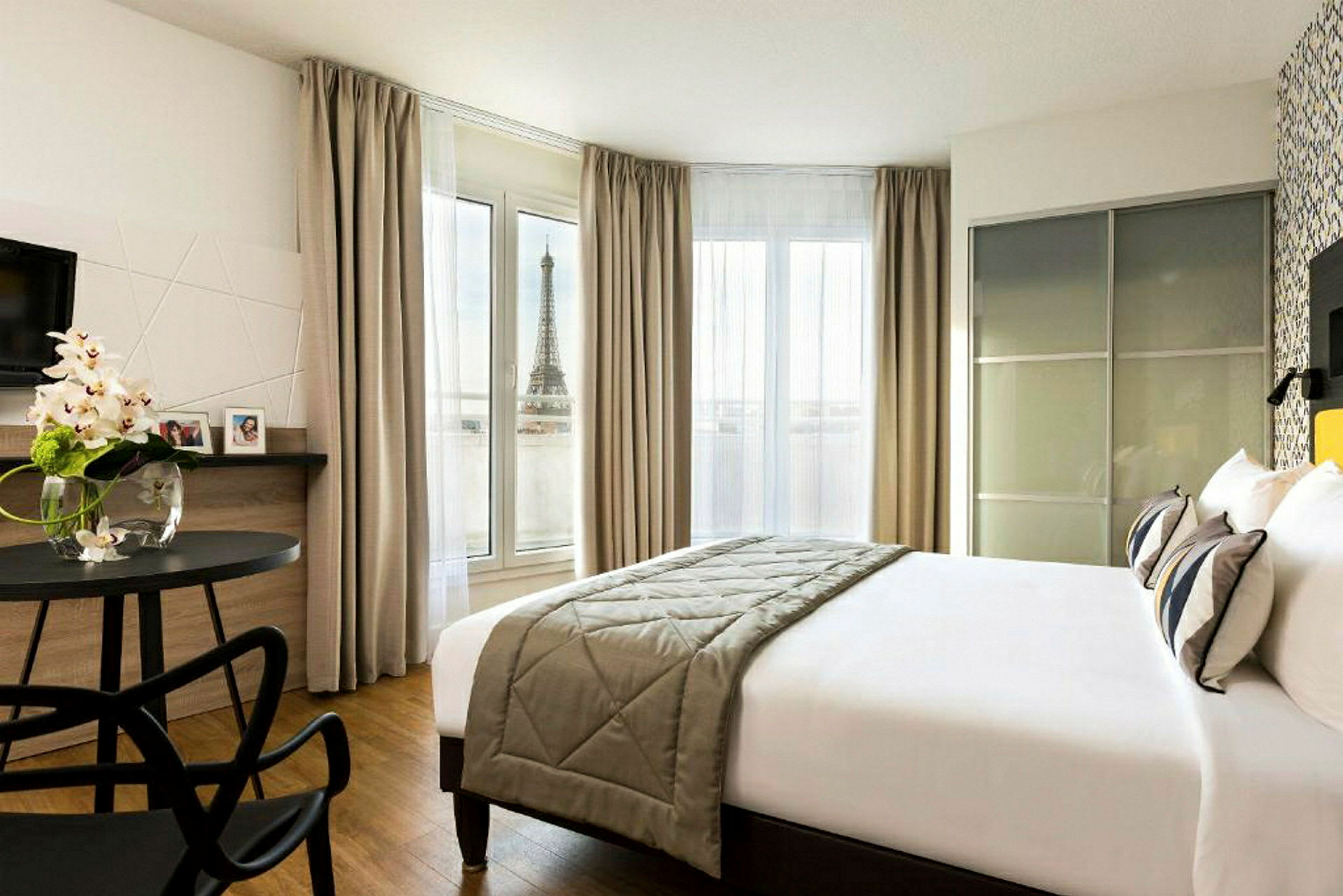 Hotellihuone, josta on näkymä Eiffel-tornille ikkunasta. (Tekoälyn luoma teksti)