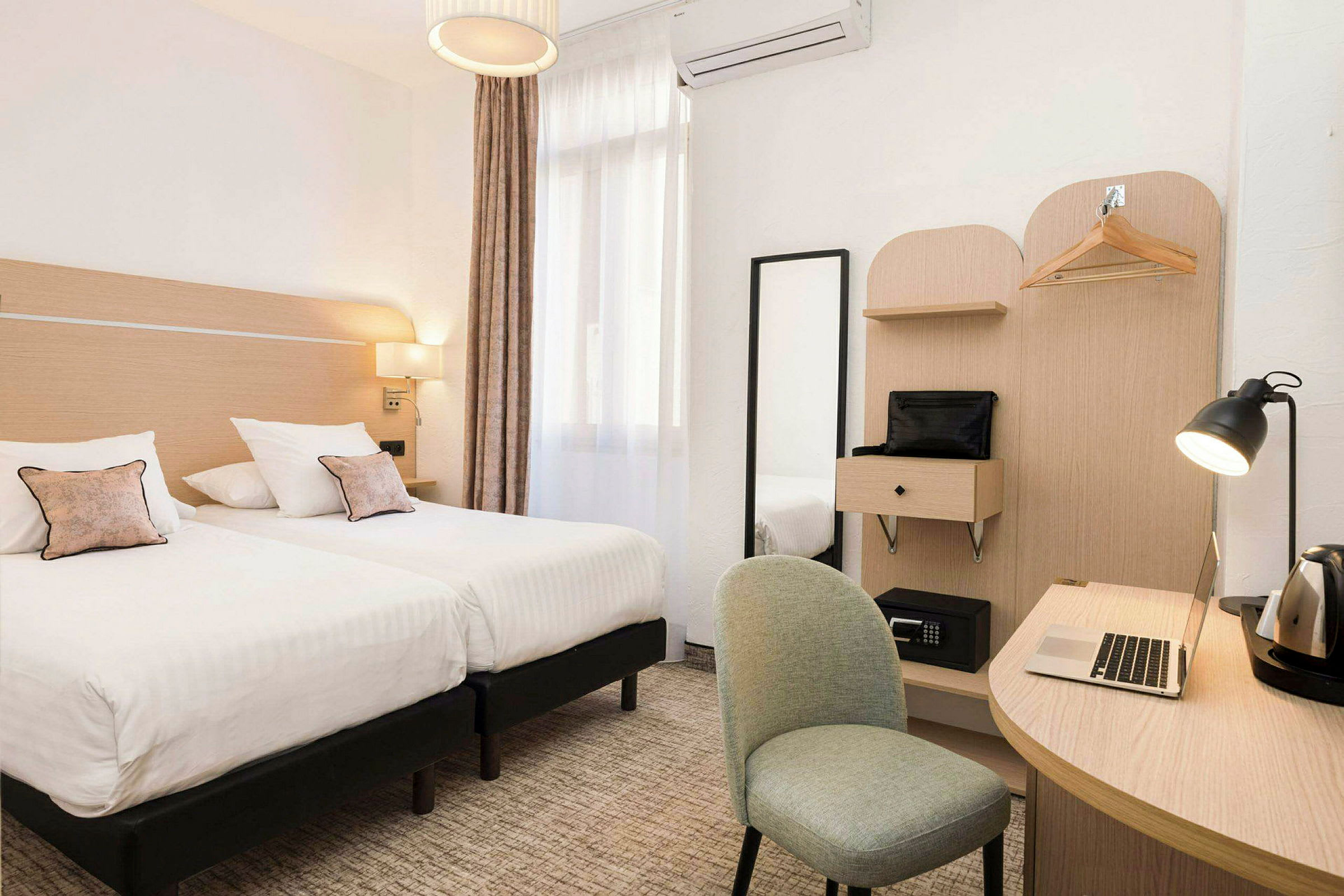 Hotellihuone, jossa kaksi yhden hengen sänkyä, kirjoituspöytä, tuoli ja vaatekaappi. (Tekoälyn luoma teksti)