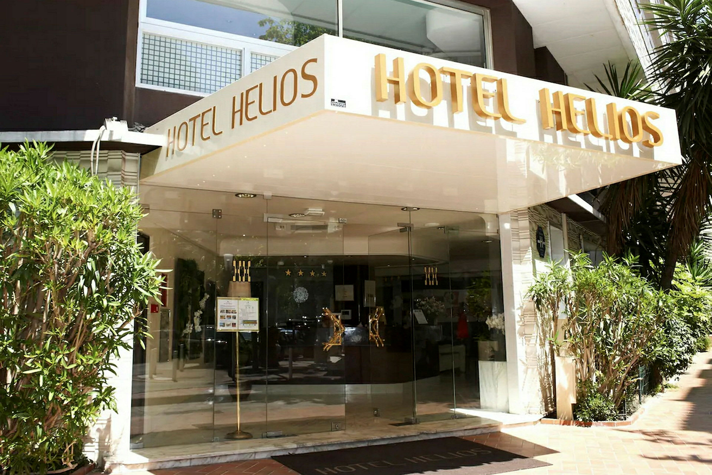 Hotel Helios -hotellin sisäänkäynti, jossa on nimi kirjoitettuna sisäänkäynnin yläpuolelle. (Tekoälyn luoma teksti)