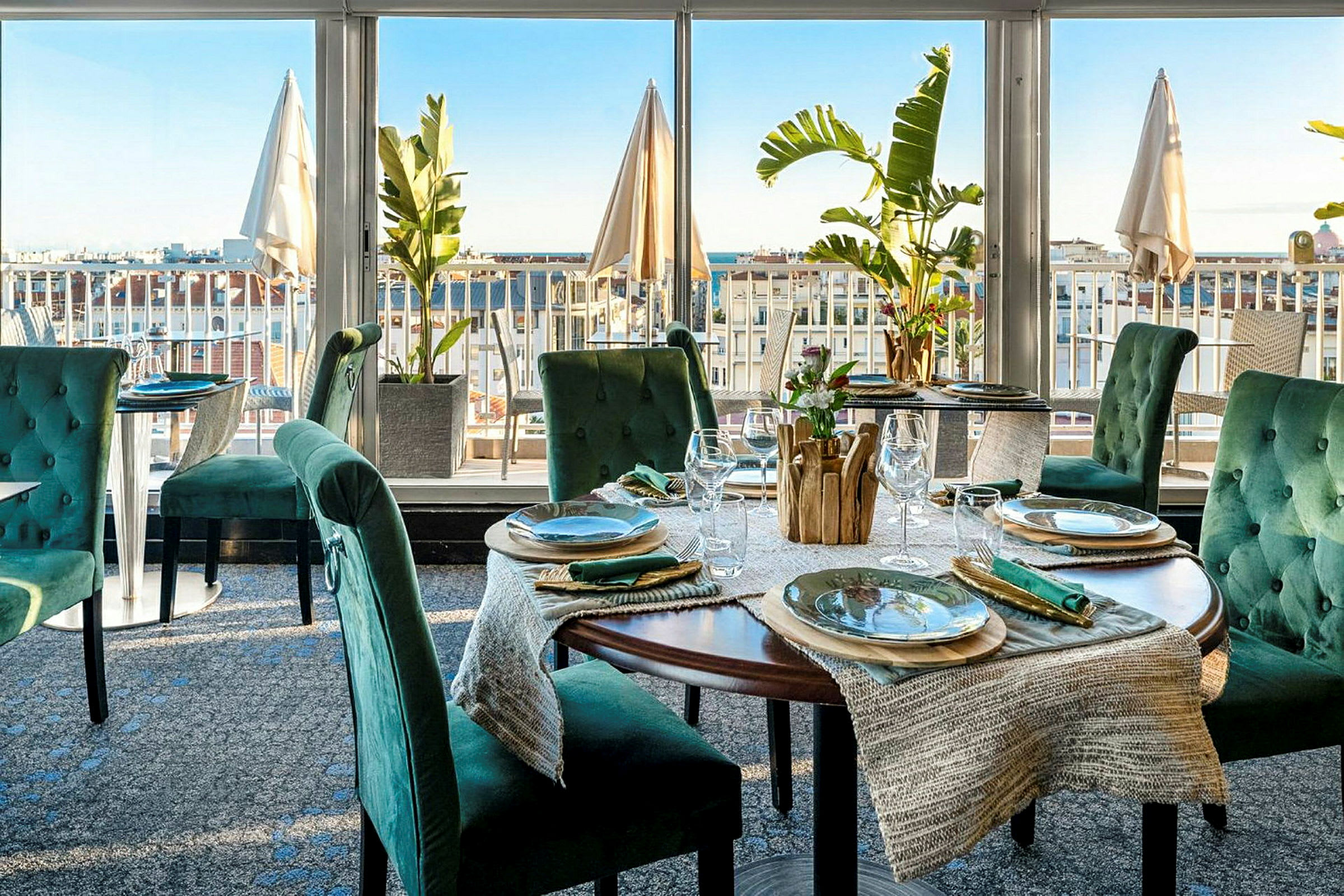 Ravintola, jossa on tyylikkäästi katetut pöydät ja näkymä kaupunkiin. (Tekoälyn luoma teksti)
