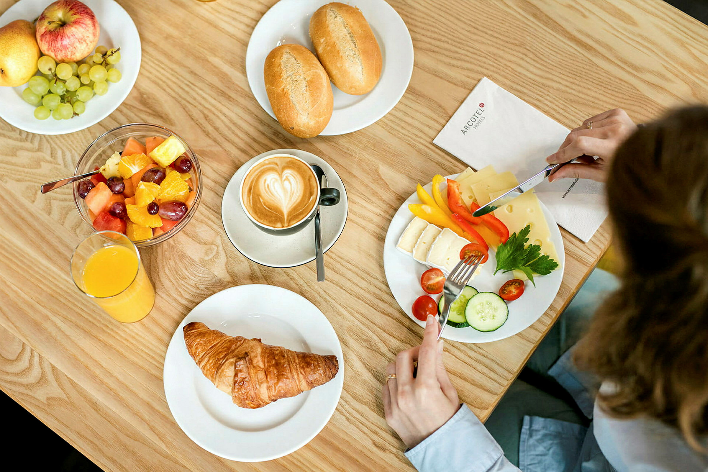 Aamiainen, jossa on kahvia, croissanttia, hedelmäsalaattia, juustoa, vihanneksia ja leipää. (Tekoälyn luoma teksti)