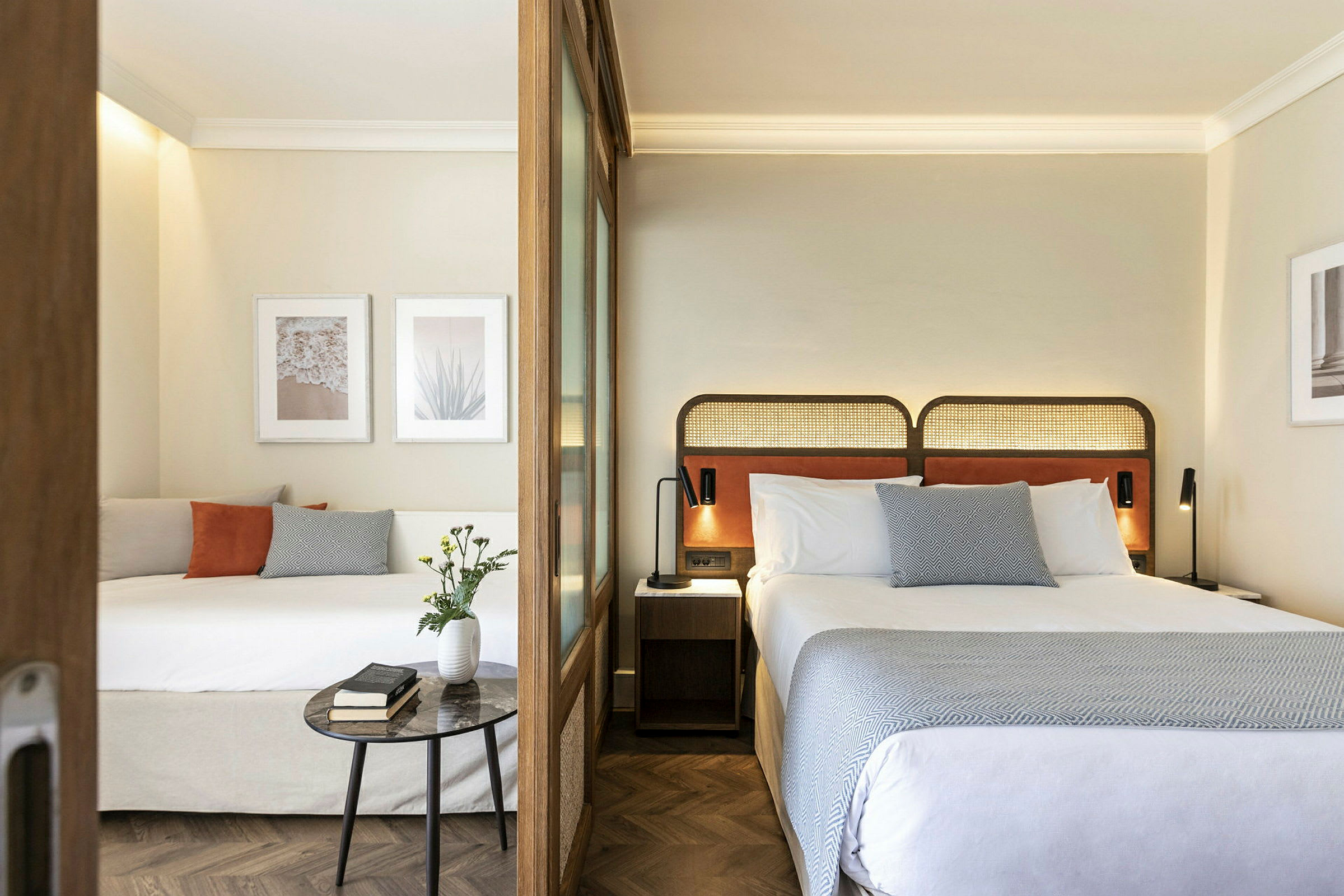 Moderni hotellihuone, jossa kaksi vuodetta, koristekuvat ja sisustus. (Tekoälyn luoma teksti)