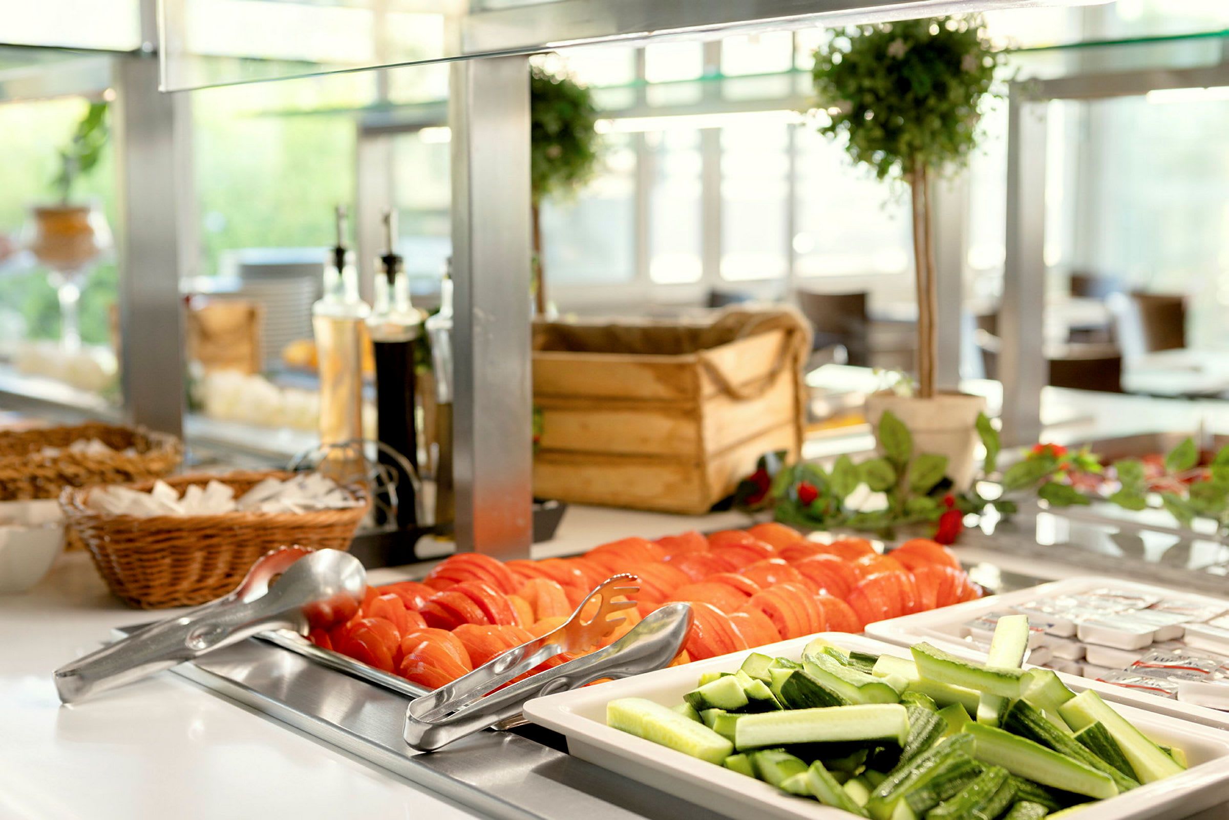 Kuvassa näkyy buffet, jossa on viipaloituja tomaatteja ja kurkkuja sekä muita lisukkeita. (Tekoälyn luoma teksti)