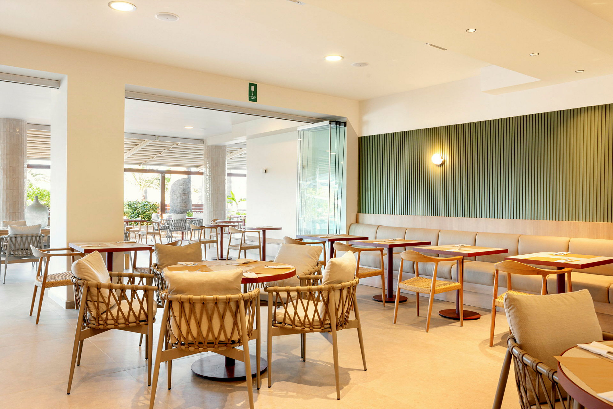 Moderni ravintola, jossa on pöytiä ja tuoleja sekä vaaleita sisustuselementtejä. (Tekoälyn luoma teksti)