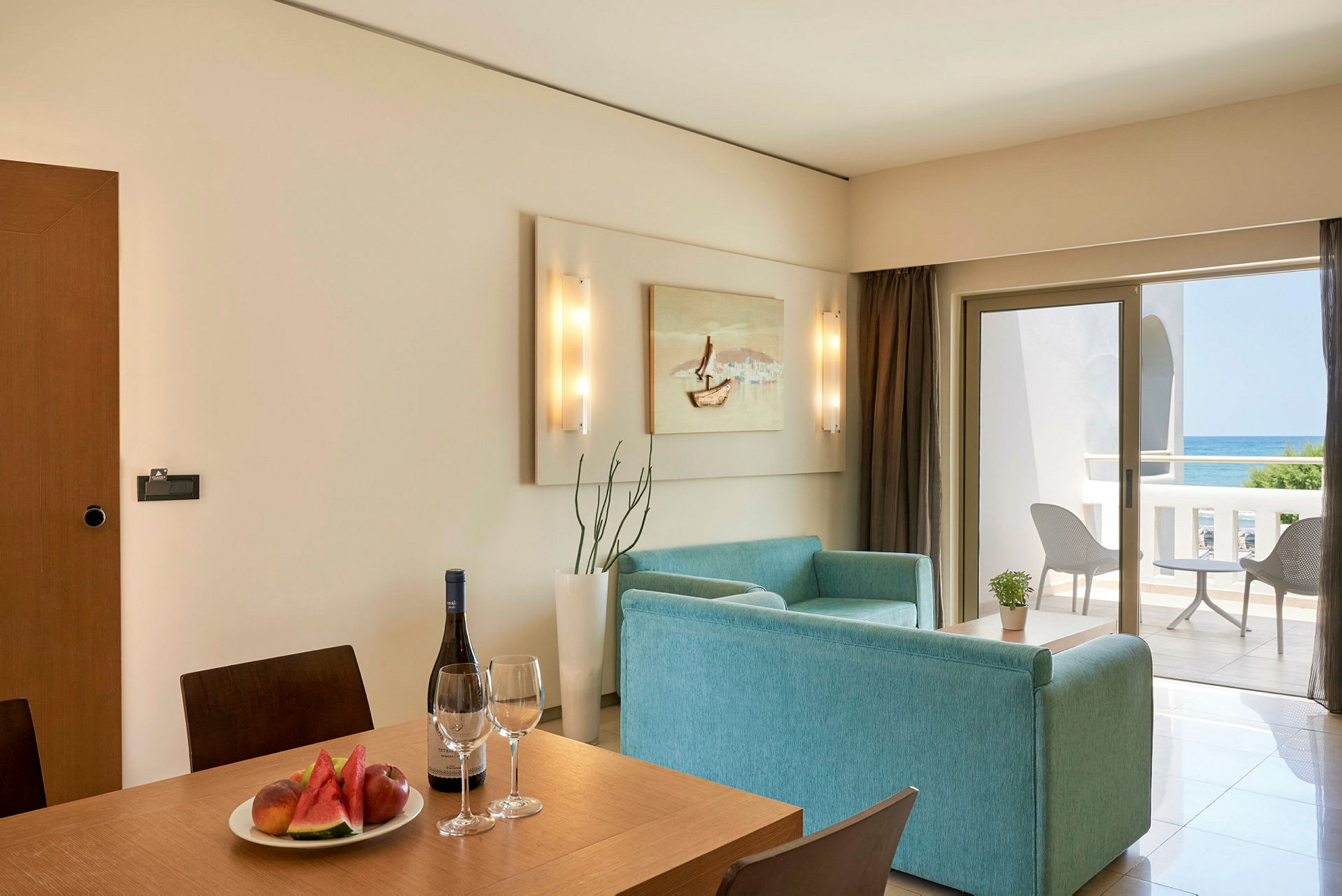 Hotellihuone, jossa ruokailualue ja oleskelutila sekä parveke merinäköalalla. (Tekoälyn luoma teksti)