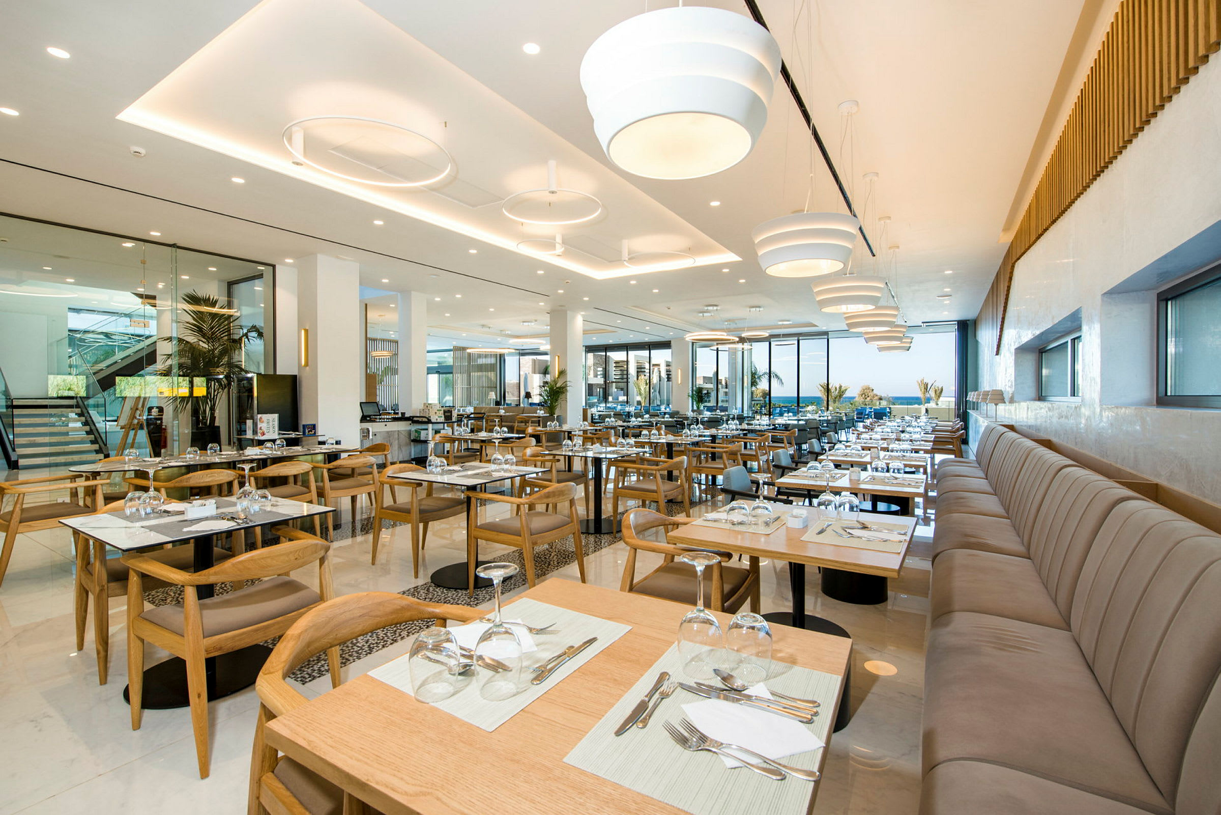 Moderni ravintola, jossa on aseteltuja pöytiä ja tuoleja sekä suuret ikkunat. (Tekoälyn luoma teksti)
