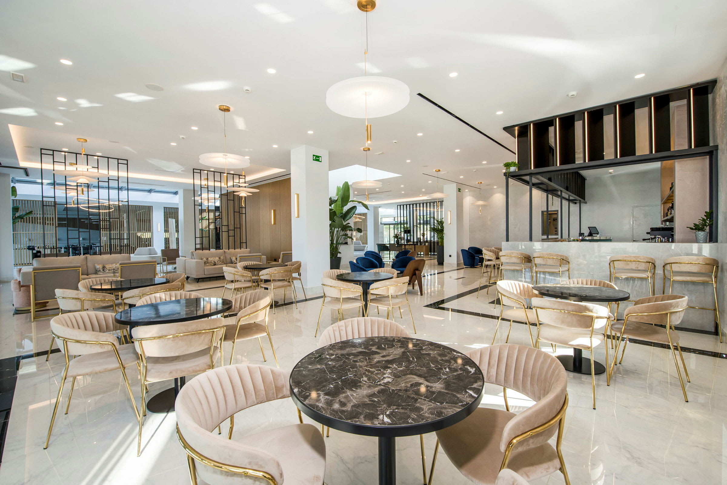 Tilava lounge, jossa istuinryhmiä ja moderni sisustettu kahvila. (Tekoälyn luoma teksti)