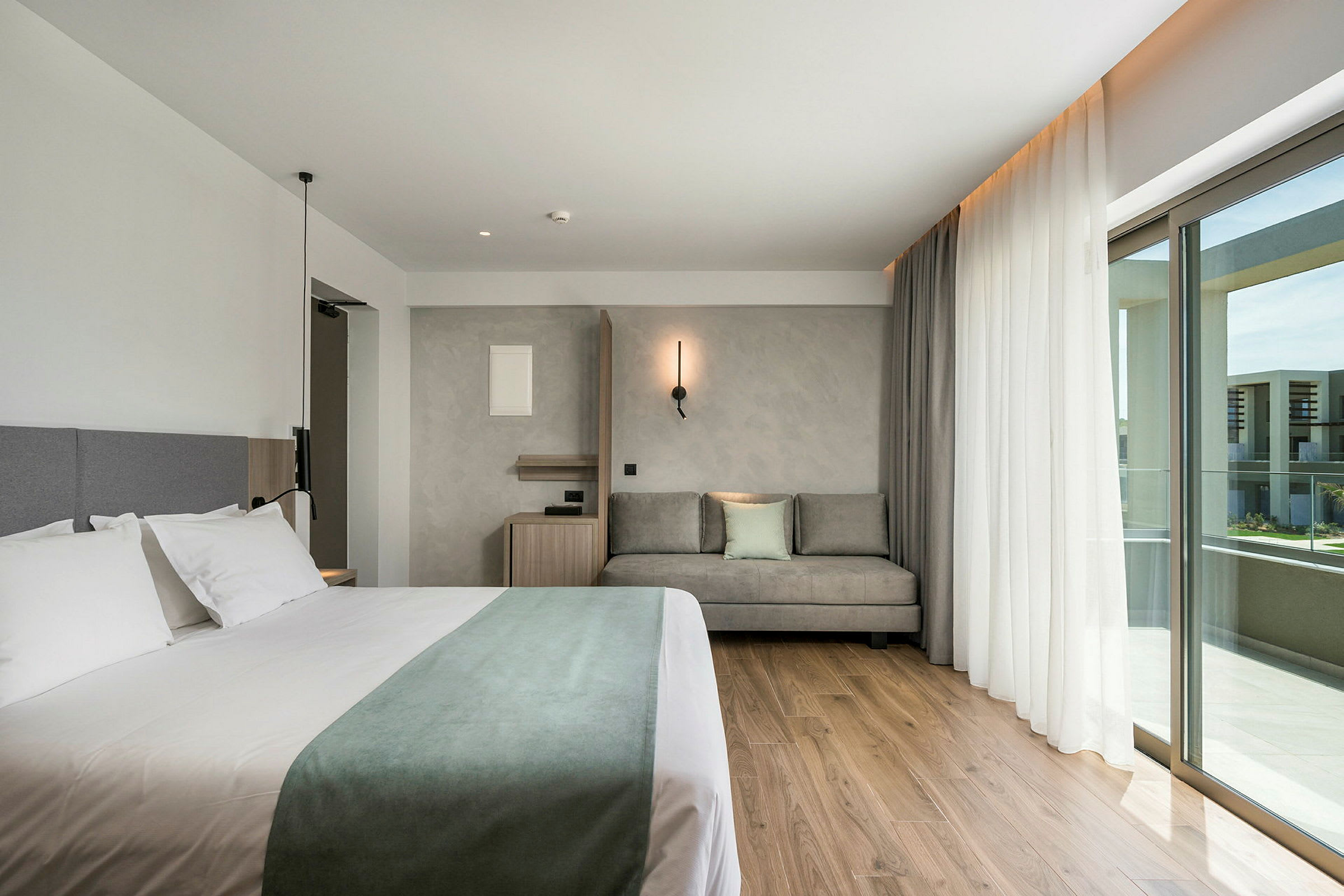 Moderni hotellihuone, jossa on parisänky ja oleskelutila. (Tekoälyn luoma teksti)