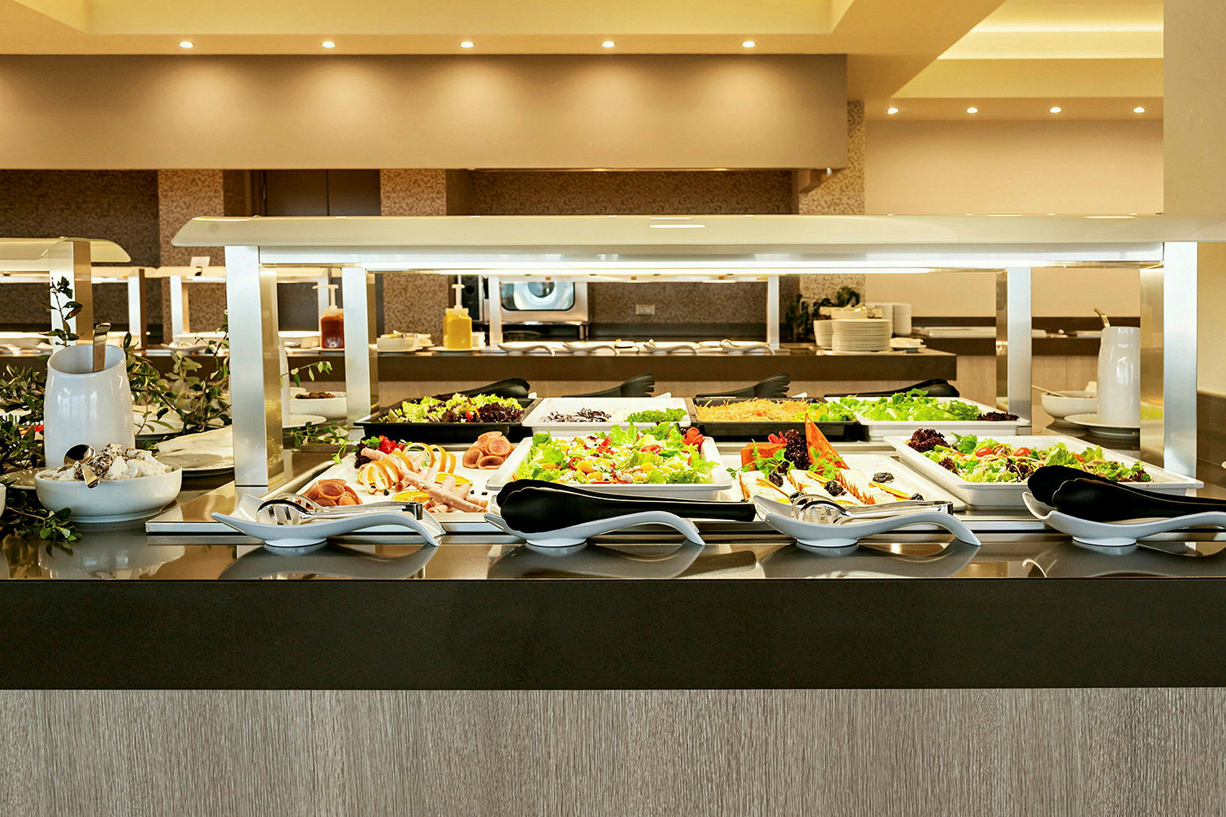 Buffet-pöytä, jossa on erilaisia ruokalajeja ja salaatteja. (Tekoälyn luoma teksti)